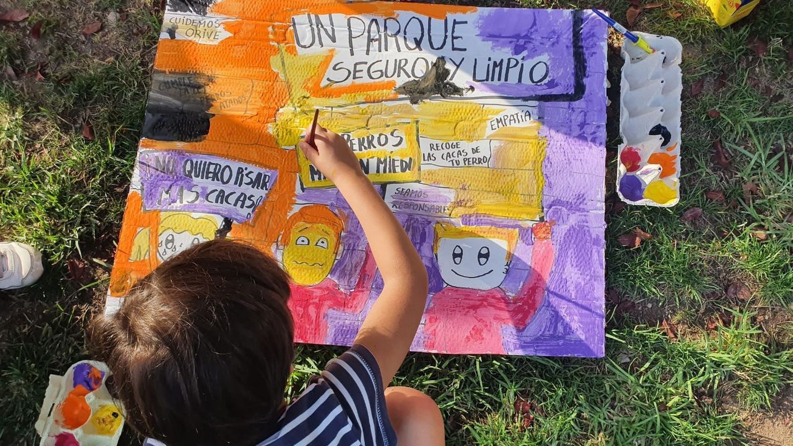 Un niño dibuja un cartel reivindicativo.
