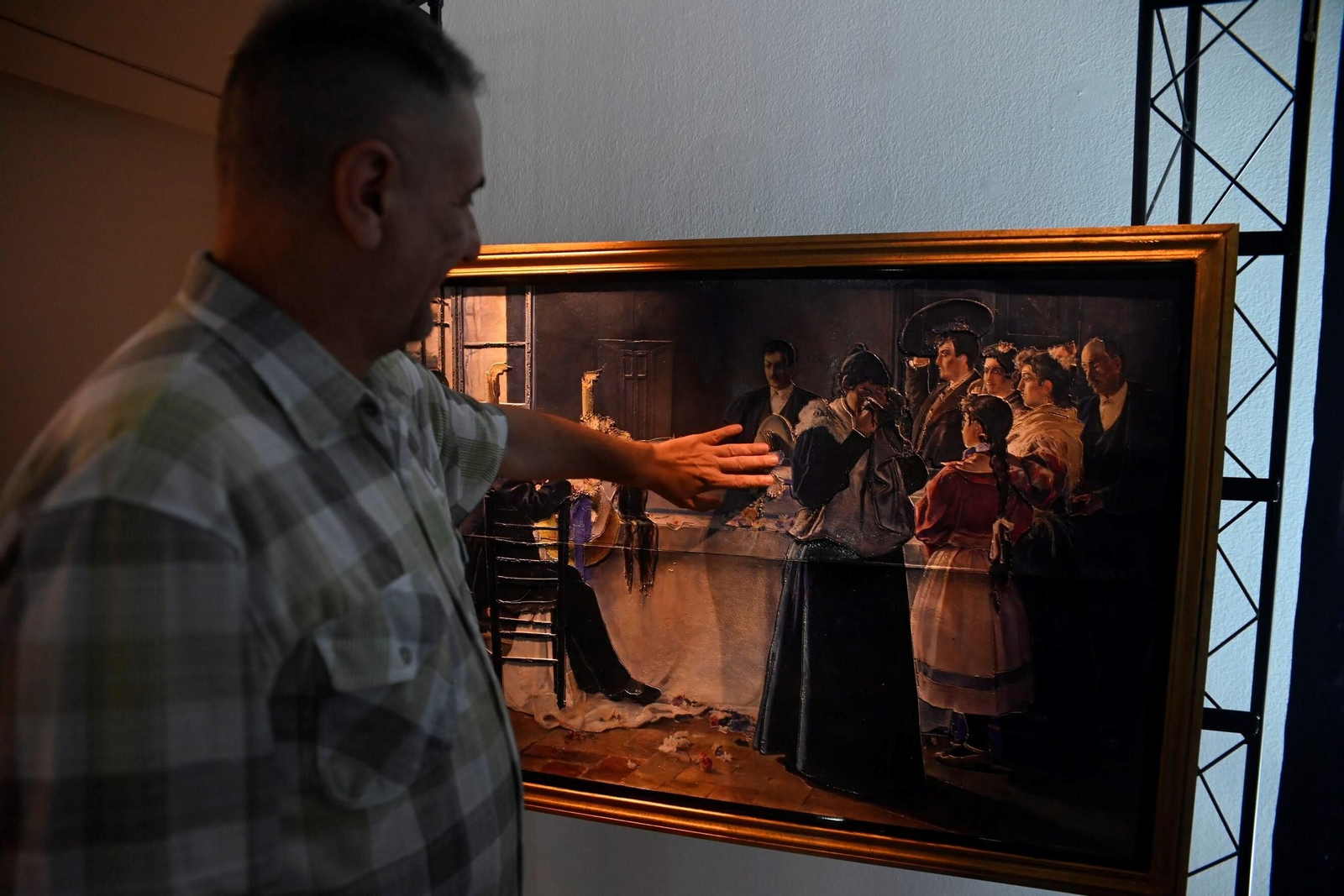 Un hombre toca una de las obras que integran la exposición.