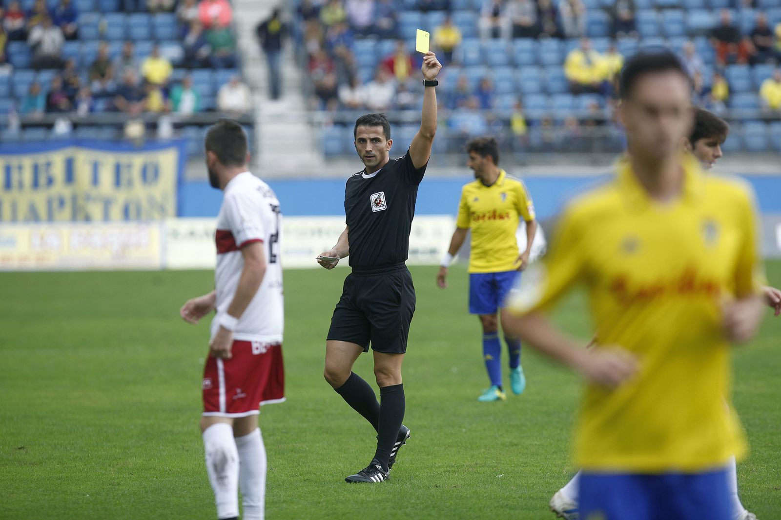 Ais Reig muestra una cartulina a un jugador del Cádiz ante el Huesca hace dos temporadas