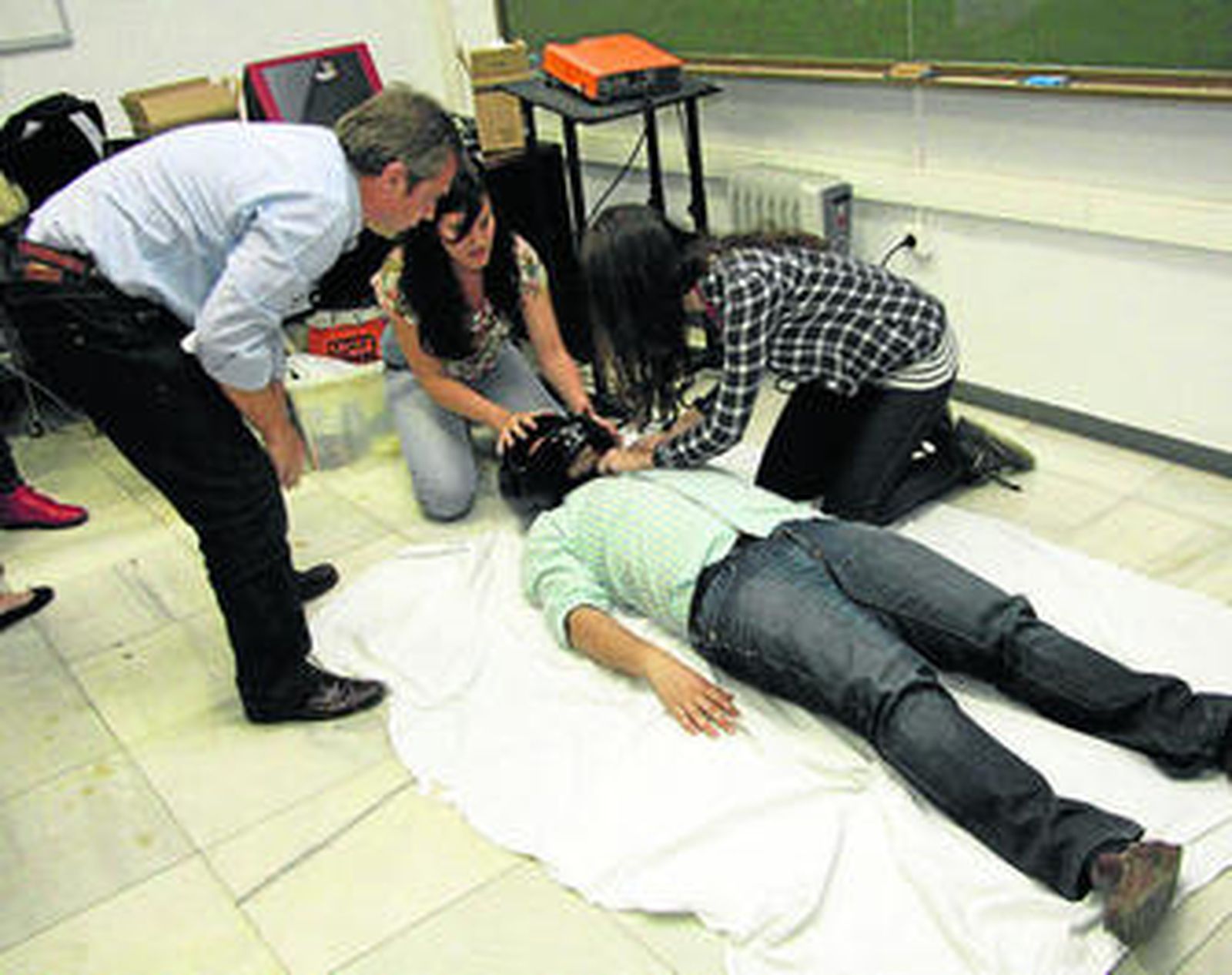 Varios alumnos practican el procedicimiento de atención a un herido en accidente de moto.