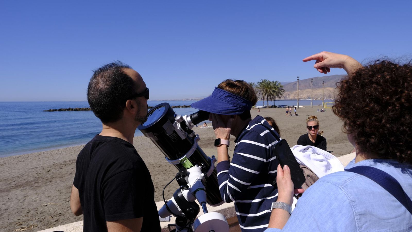 Almería observa el eclipse solar desde el Paseo Marítimo, en imágenes