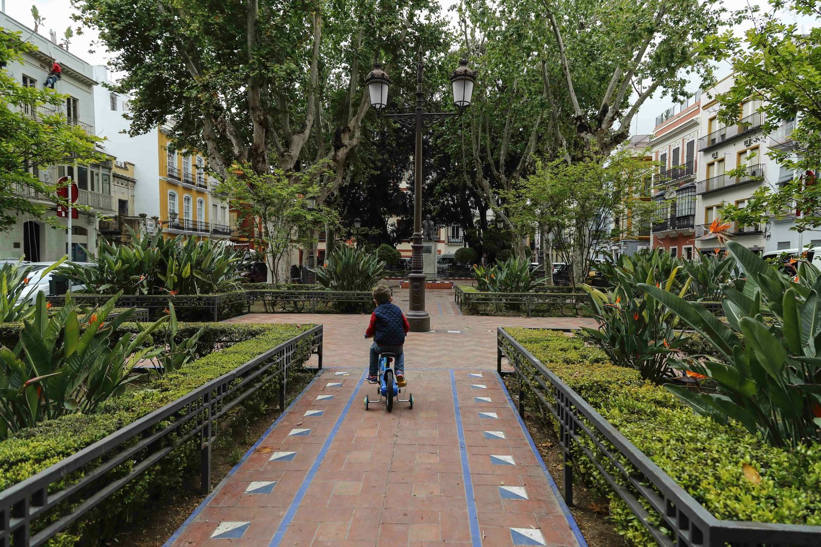 Un niño en bicicleta por el recuperado jardín de la plaza Cristo de Burgos.