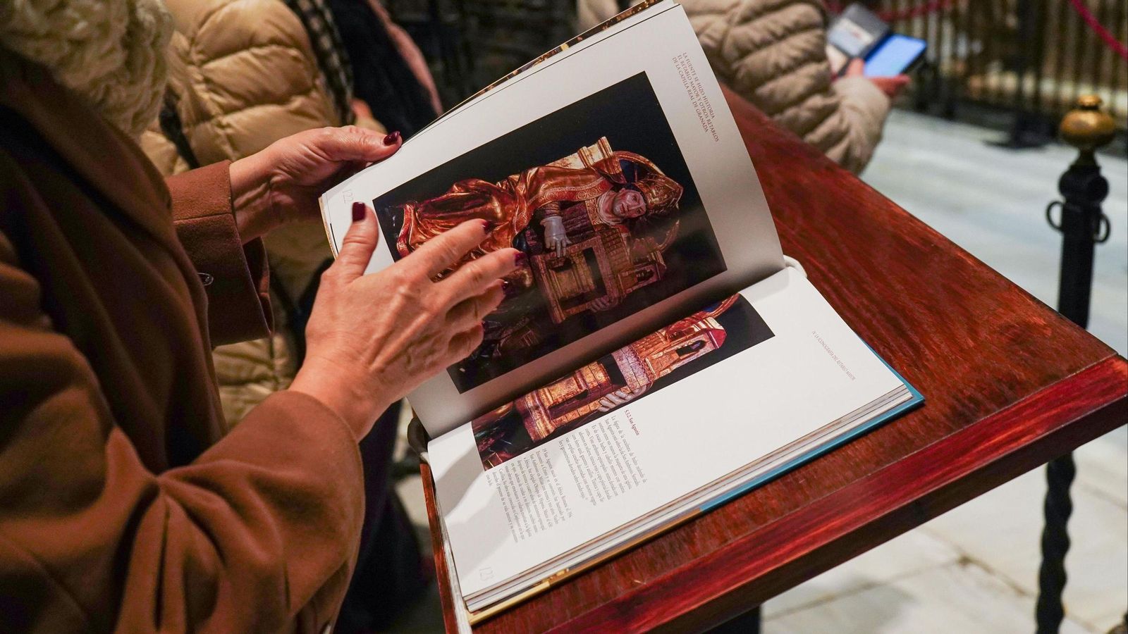 Una mujer observa el libro 'La Fuente se Hizo Historia' en Granada