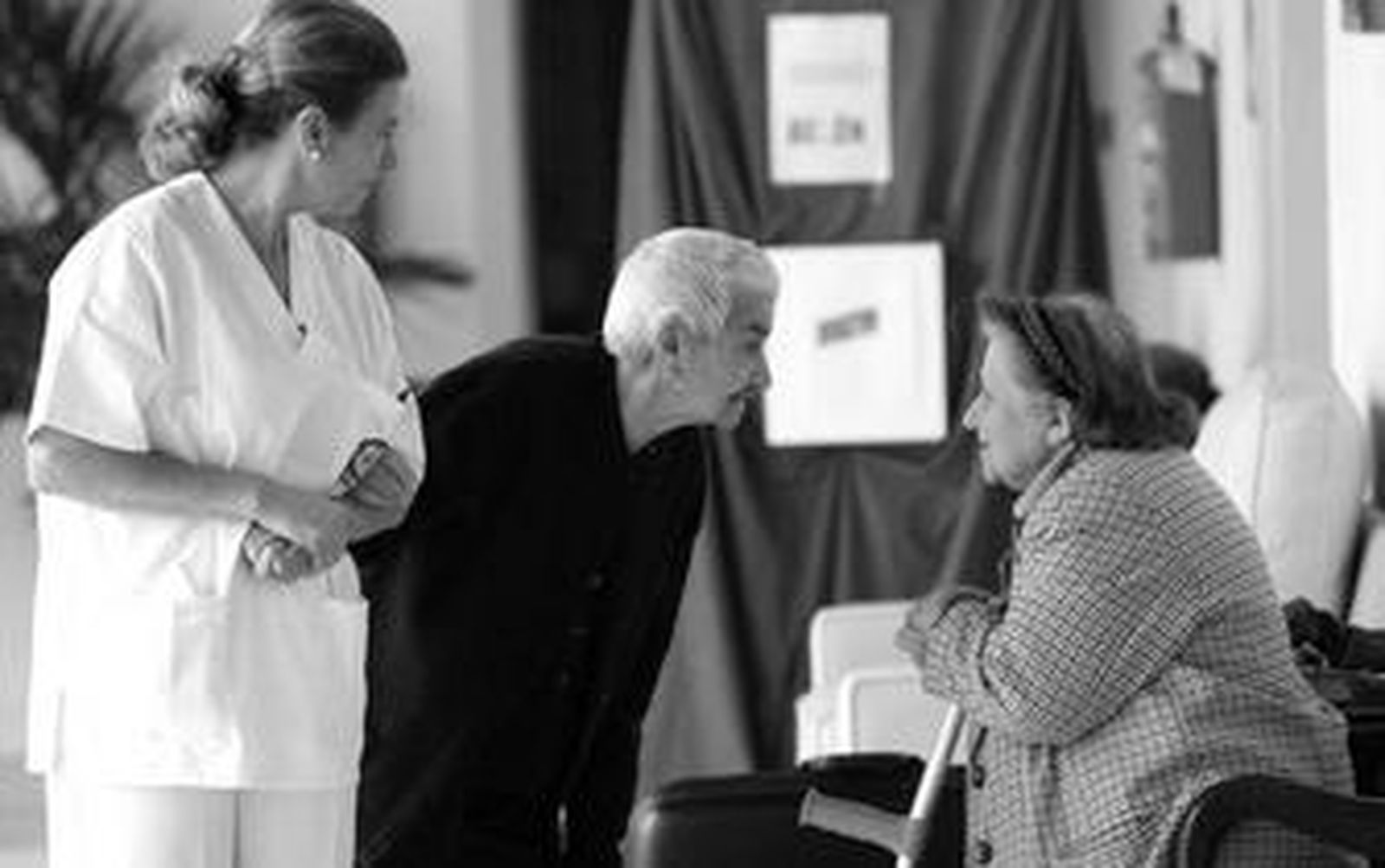 Cristobalina Rendón, acompañada por una enfermera, saluda en los pasillos de Fragela a su nueva compañera Eloísa Jiménez.