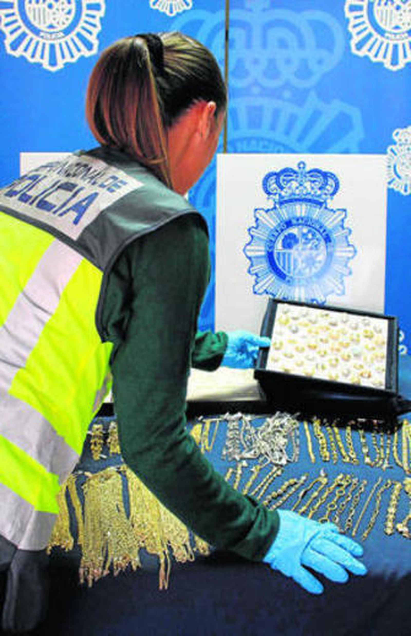 Una policía manipula las joyas recuperadas.