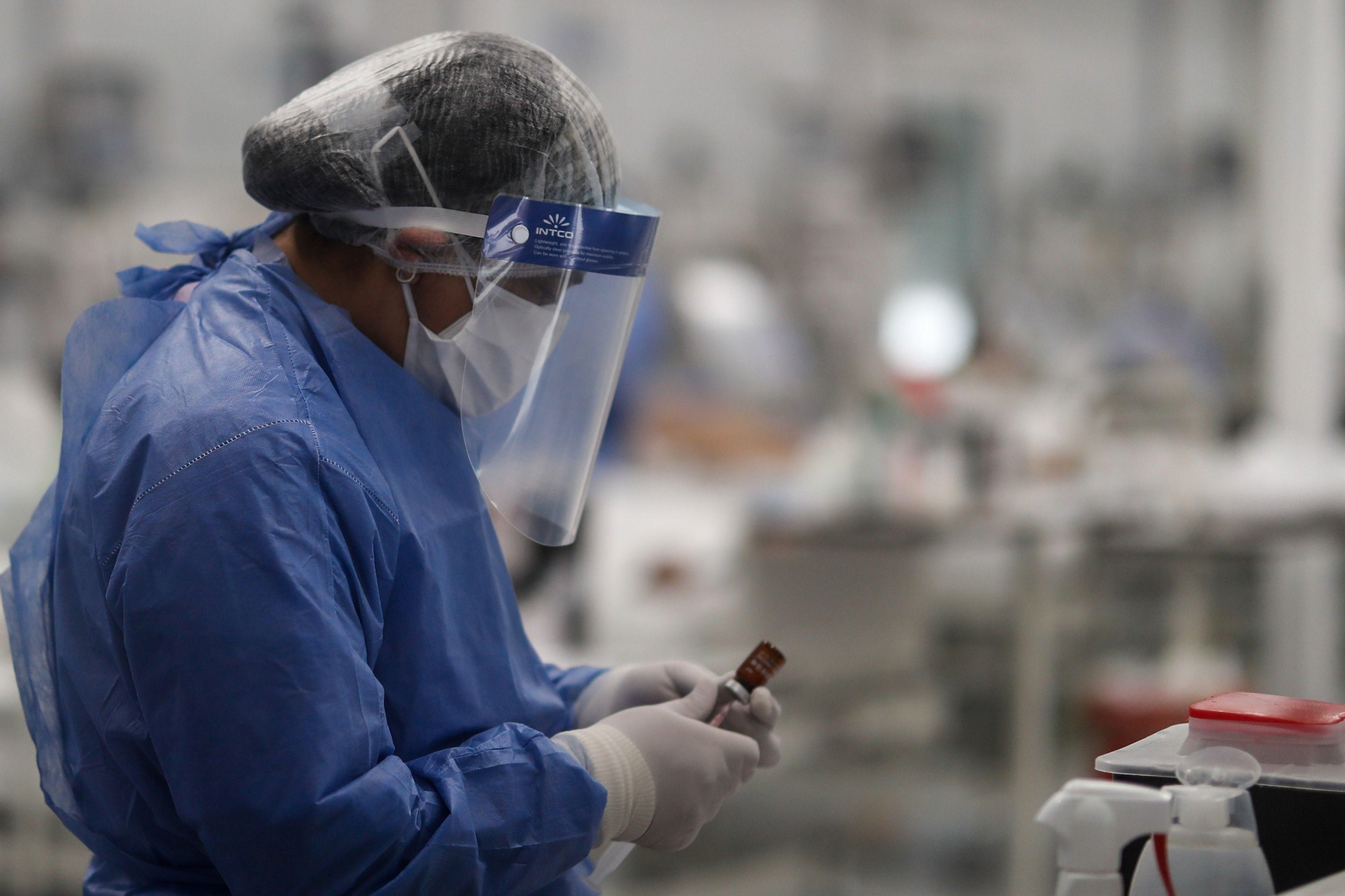 Una médica prepara un tratamiento para un paciente.