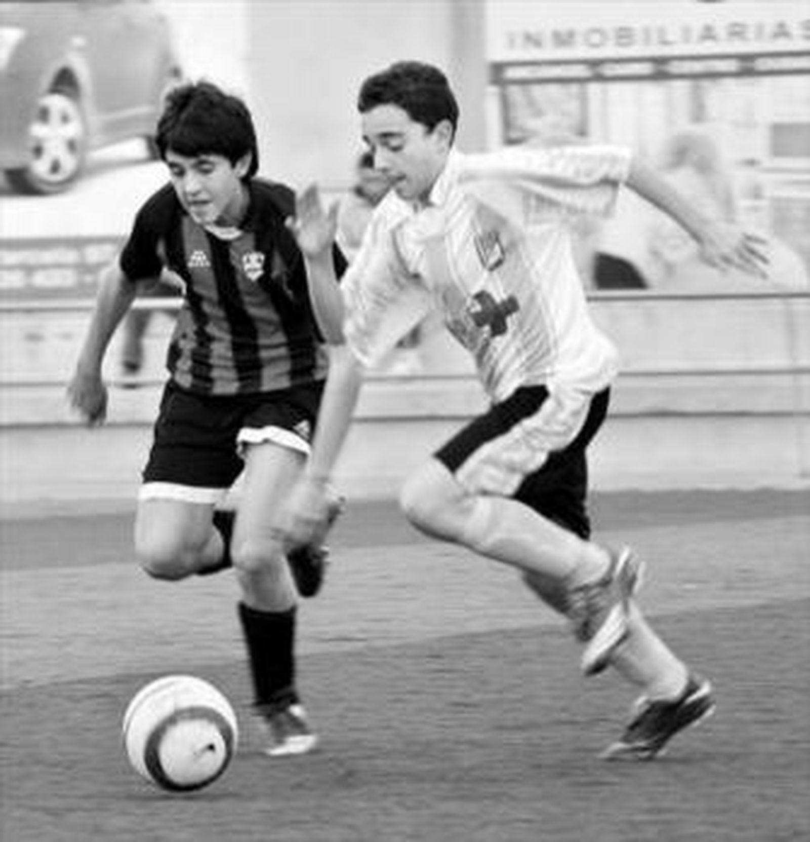 Un jugador rojinegro sale al paso de uno del Don Bosco.