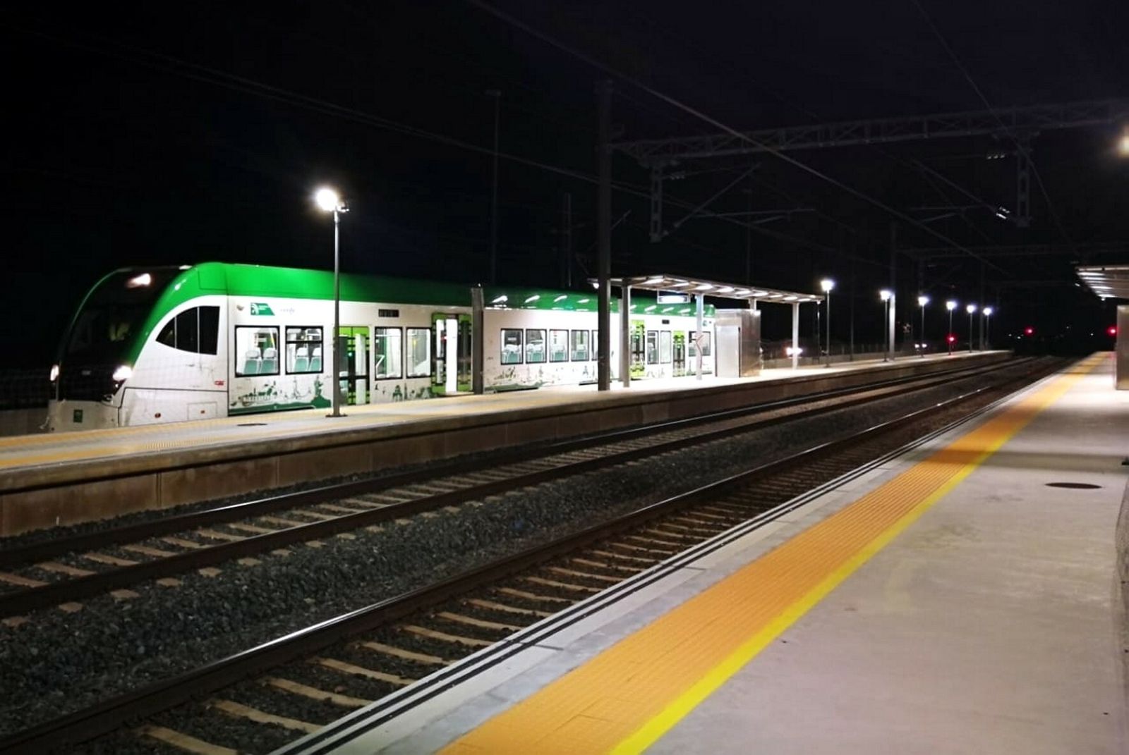 Una de las unidades del tranvía, en la parada de Río Arillo, junto a las vías del tren.