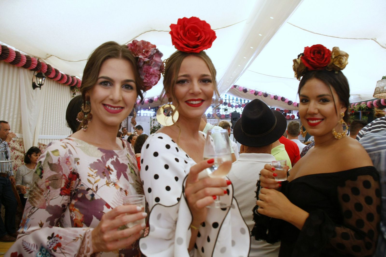 Unas jóvenes, perfectamente ataviadas con  sus trajes de flamenca.