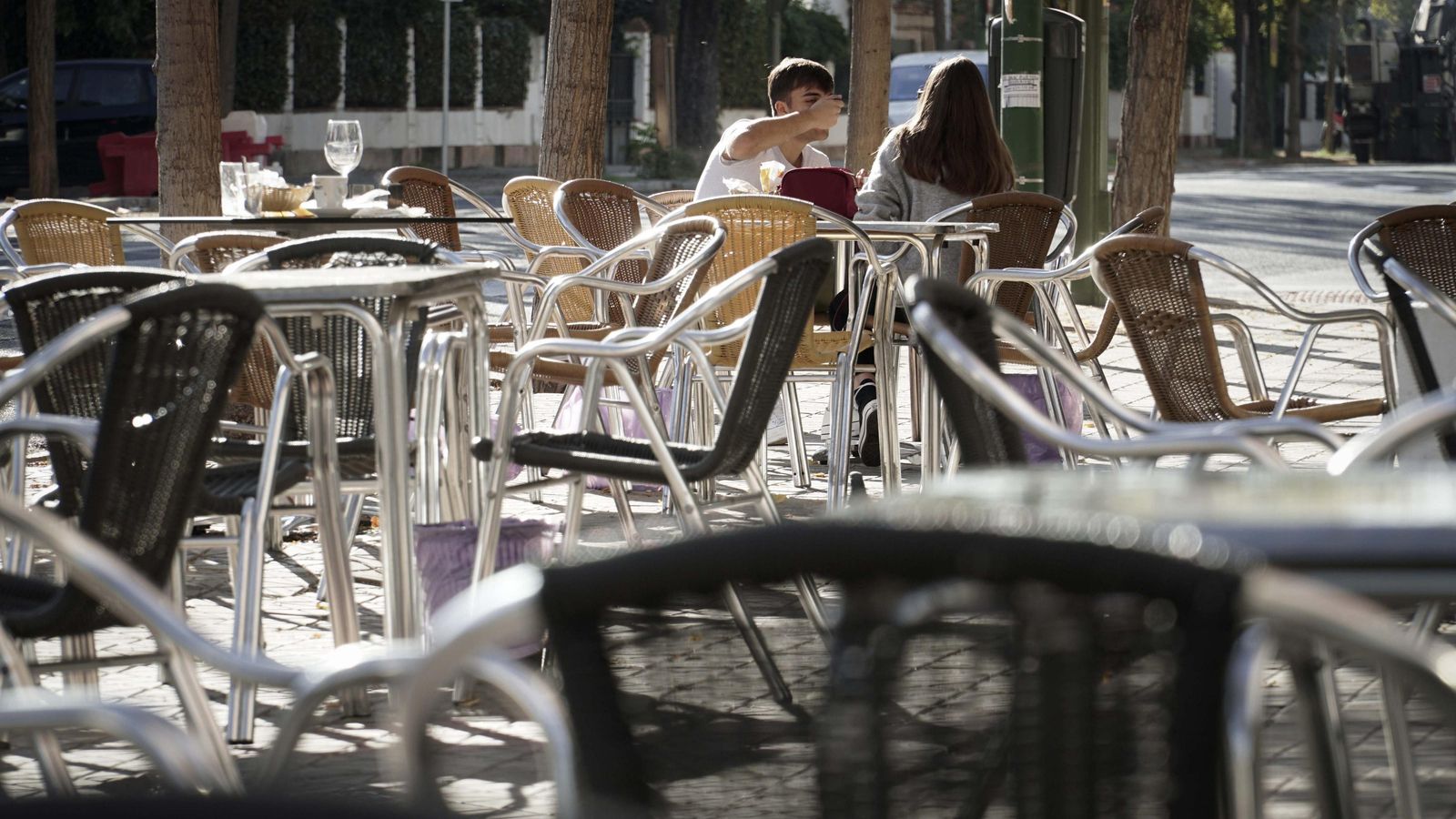 Terraza de un bar con casi todos los veladores vacíos.