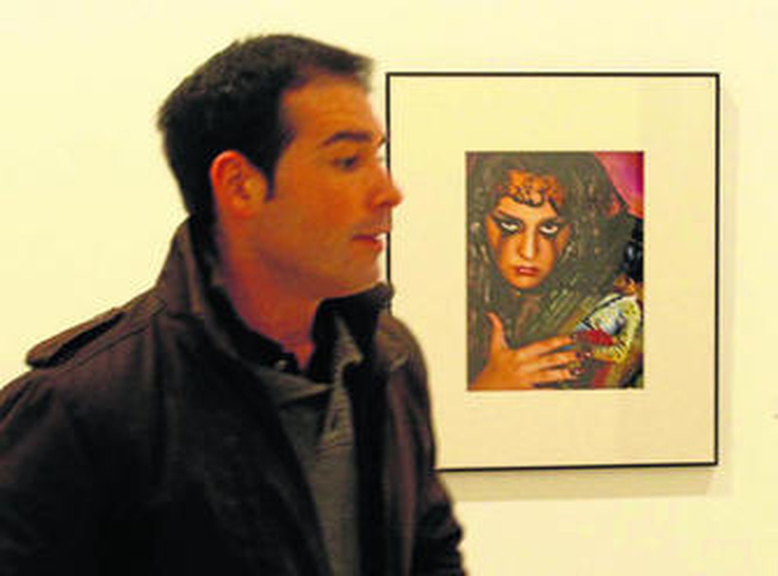 Un visitante en la exposición junto a una de las fotografías seleccionadas.