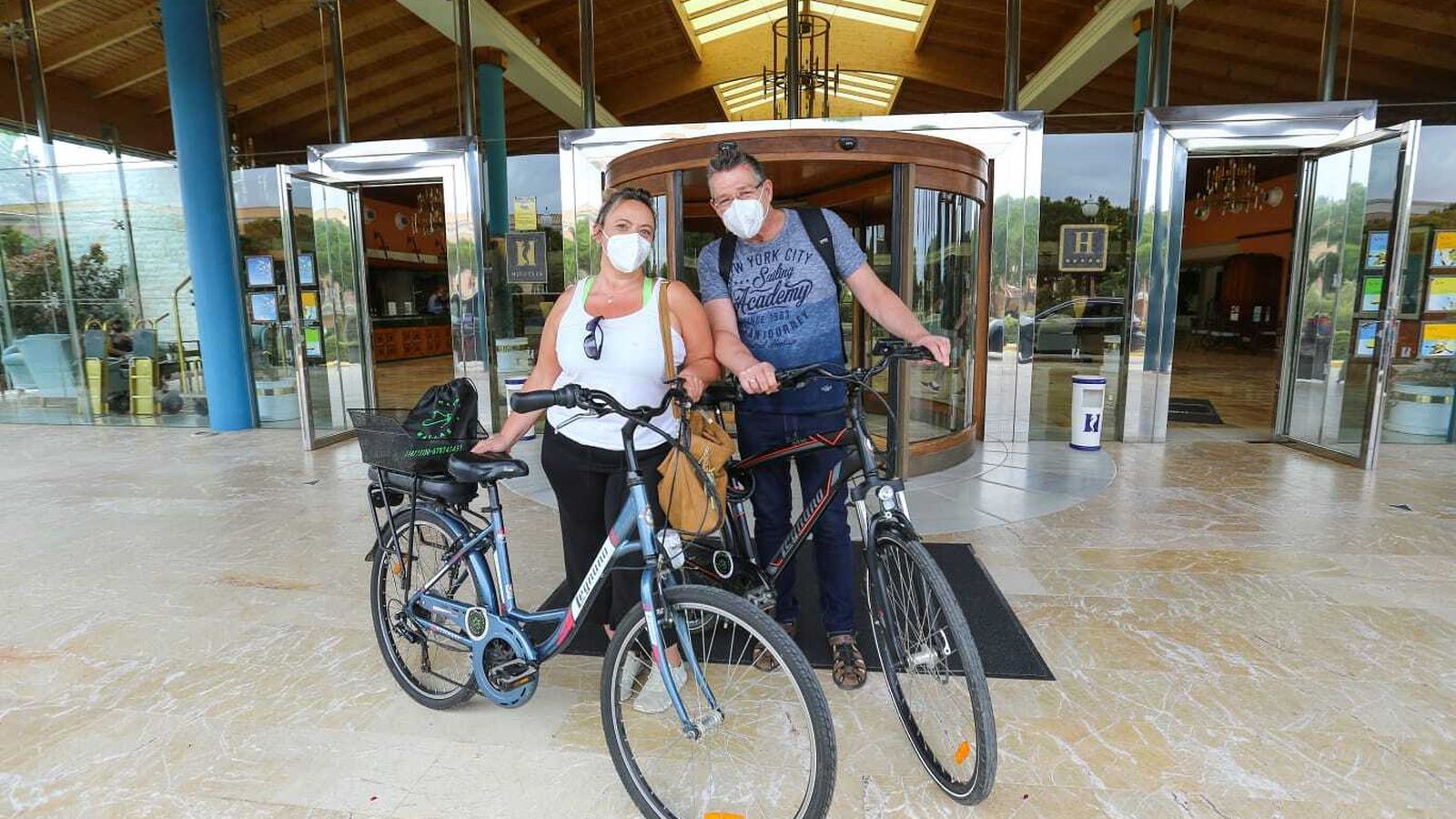 Stephan y Curina, alemanes, con sus bicicletas de alquiler ante el Hipotels Barrosa Palace.