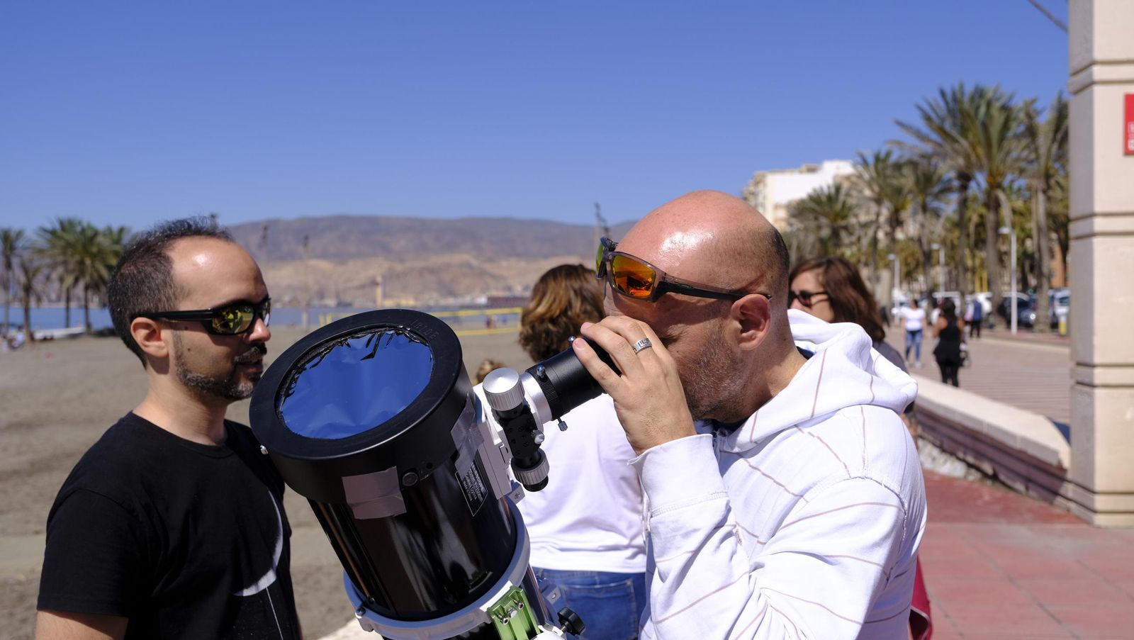 Almería observa el eclipse solar desde el Paseo Marítimo, en imágenes