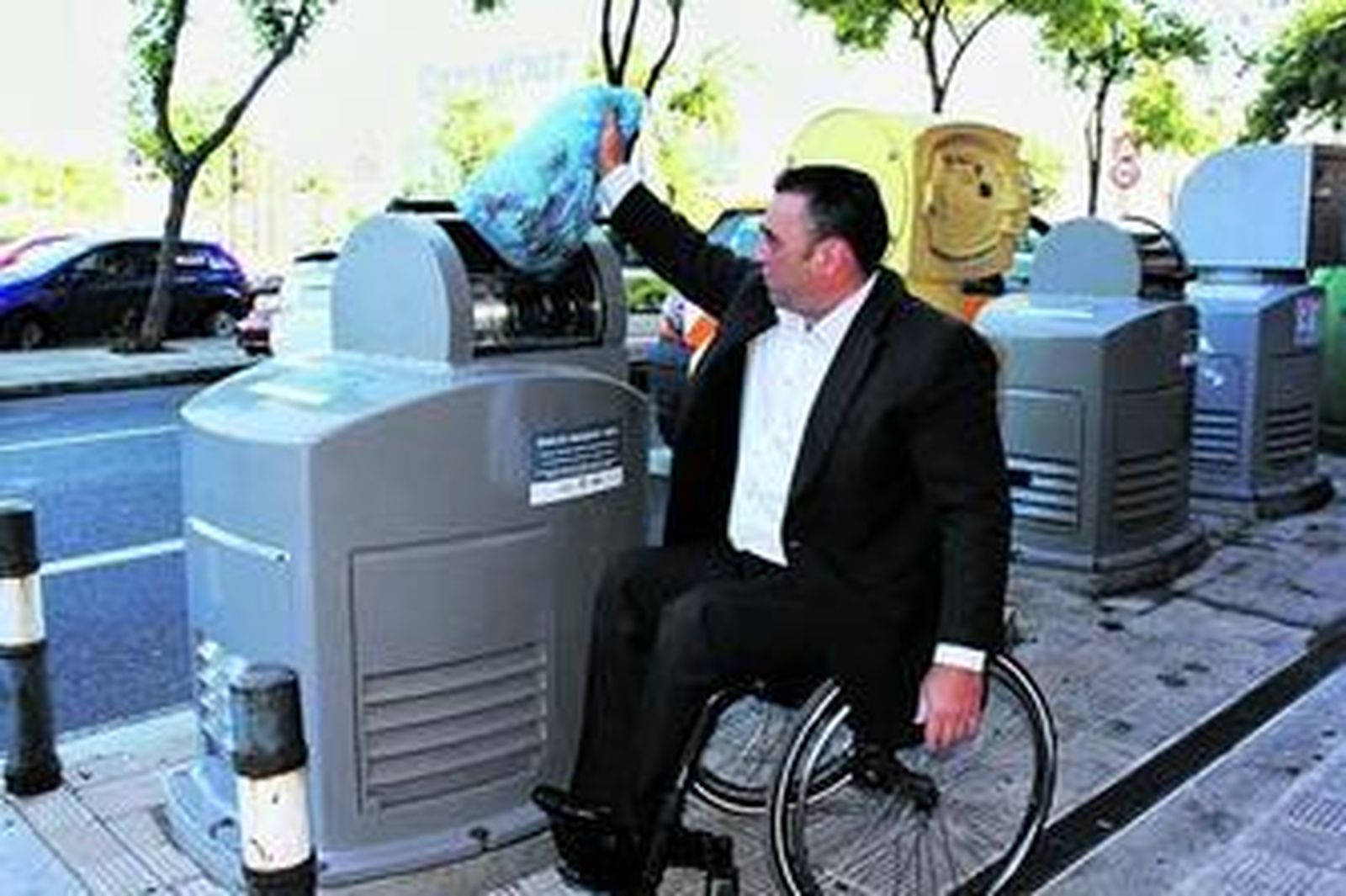 El concejal del distrito Norte, Juan García Camacho, deposita una bolsa en un contenedor nuevo.