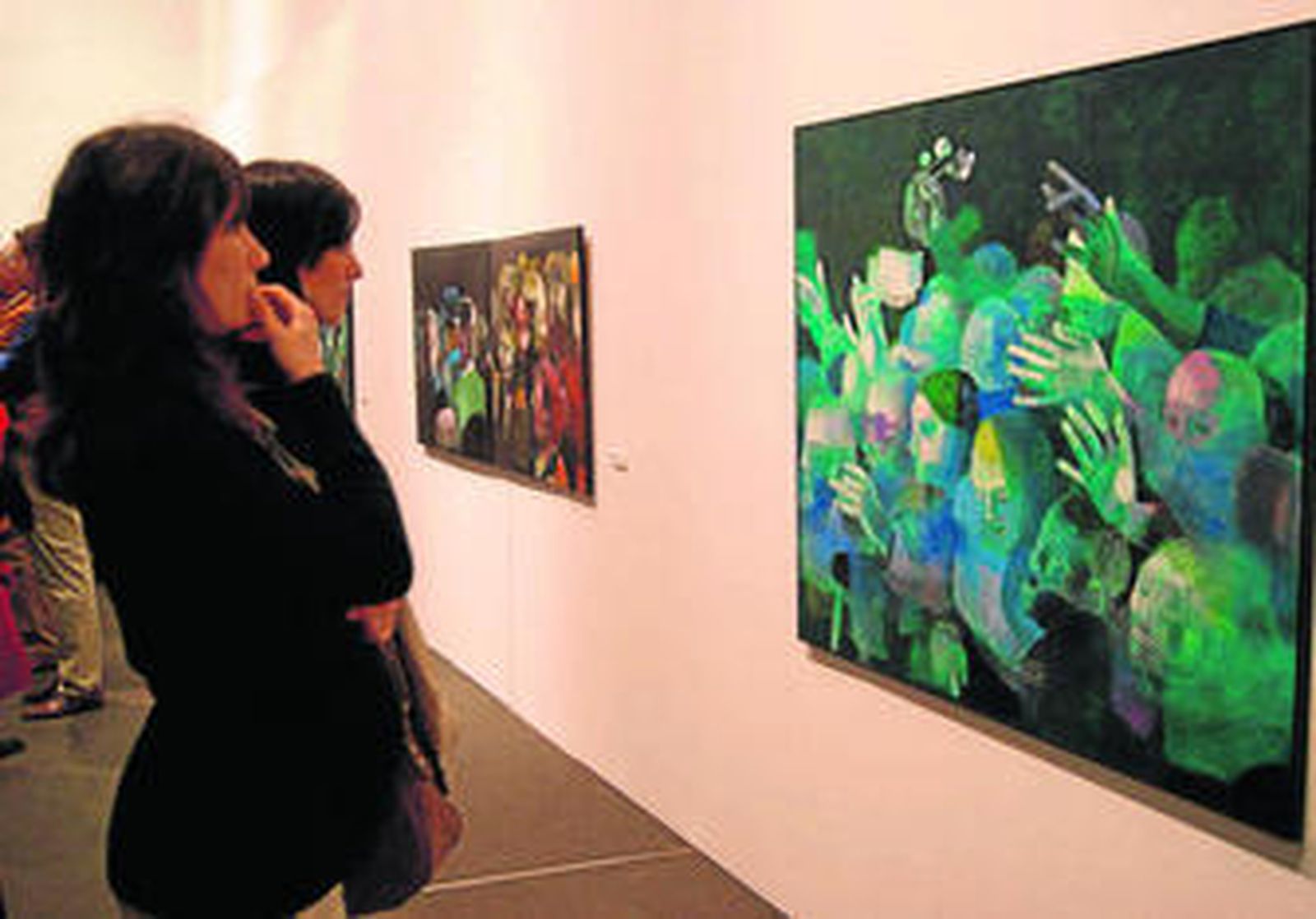 Dos jóvenes miran uno de los cuadros de la exposición del Monasterio de Santa Clara.