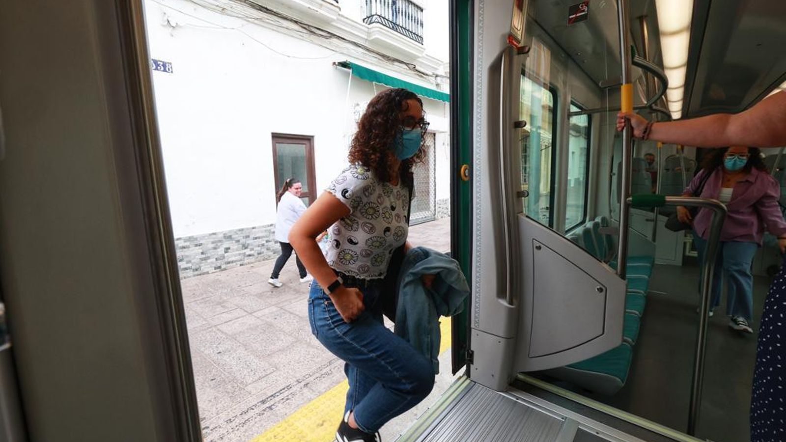 Una viajera se sube al tranvía en una parada de San Fernando.