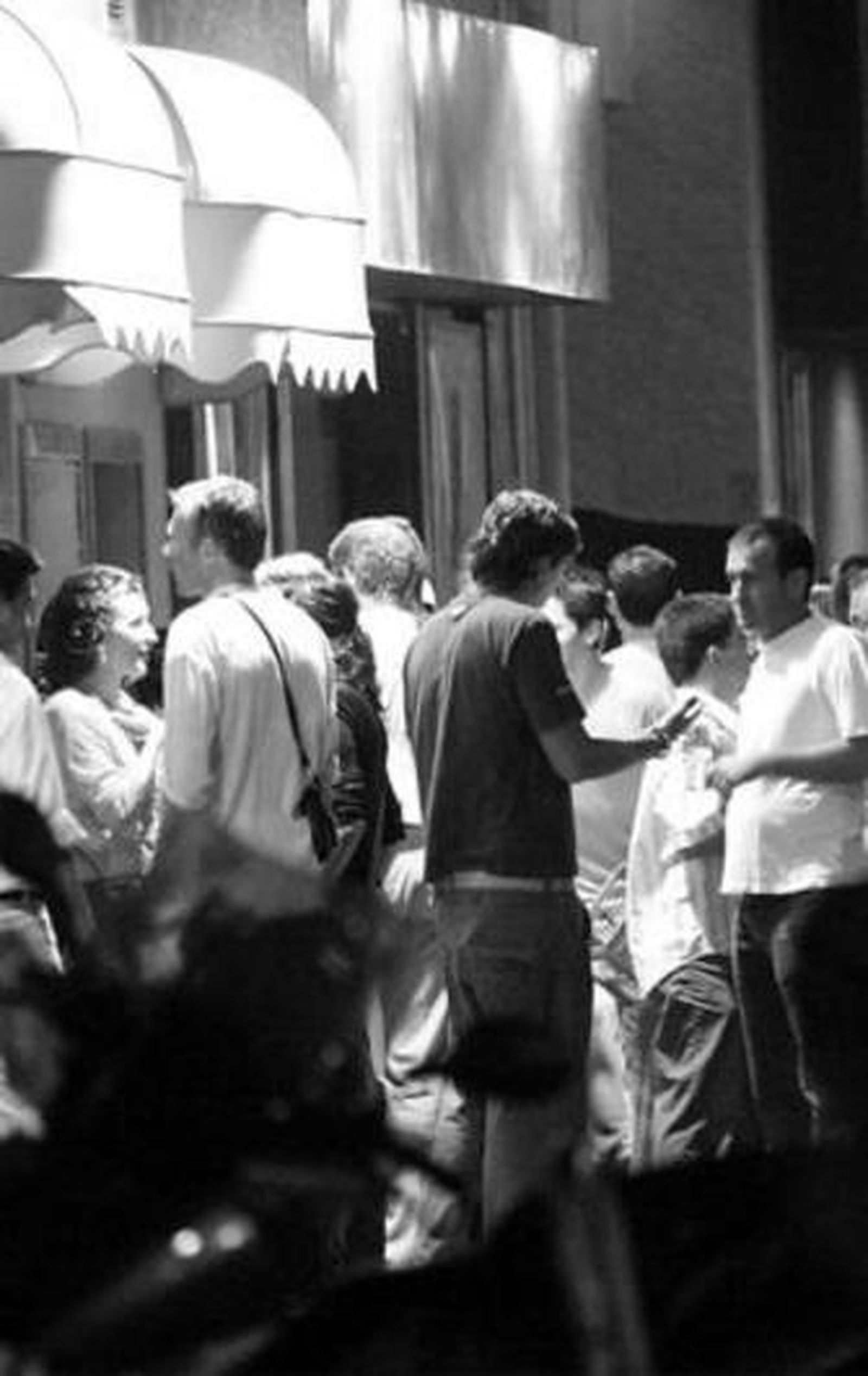Un grupo de personas conversa de noche en la calle Muñoz Arenillas.
