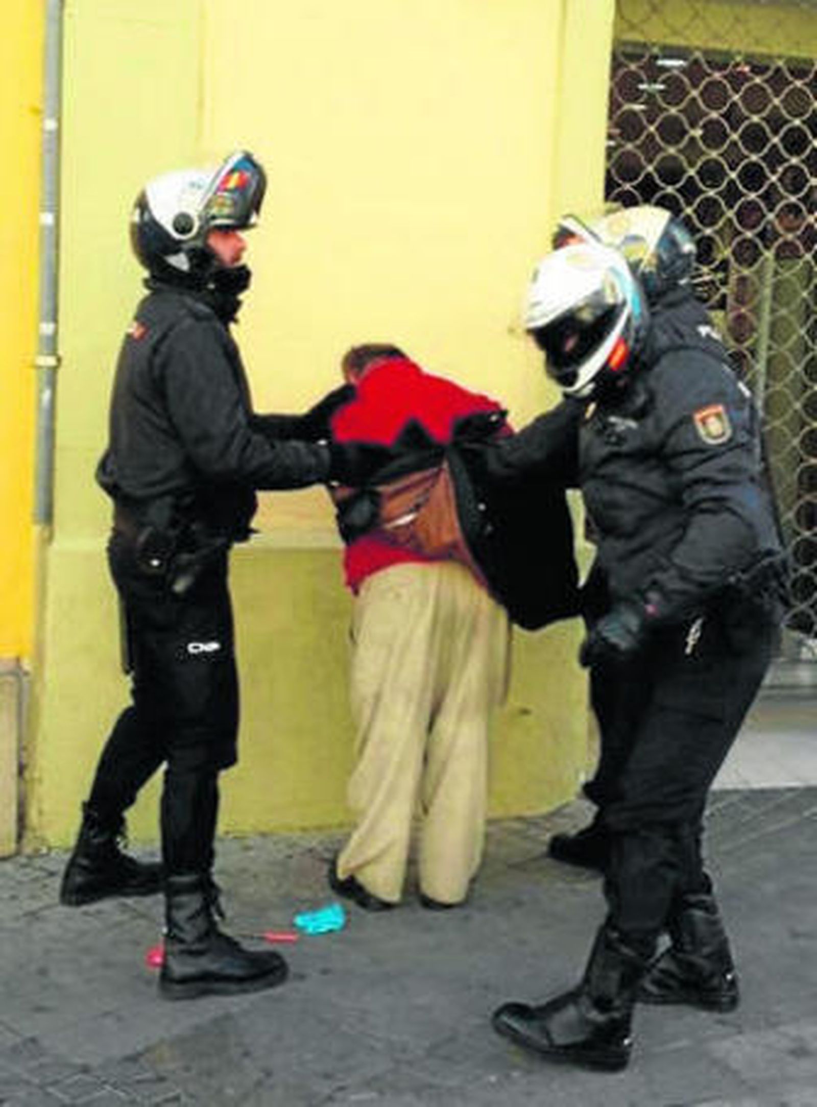 El detenido, esposado por la Policía antes de ser trasladado a Comisaría.