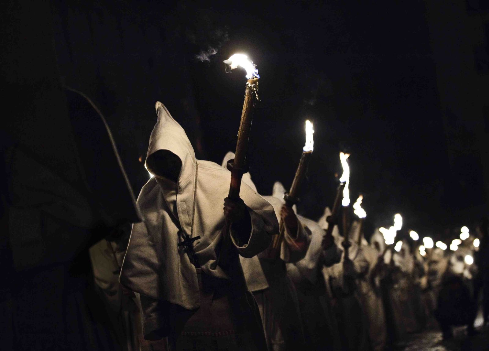 Penitentes de la Hermandad del Cristo de la Buena Muerte procesionan por una calle de Zamora.