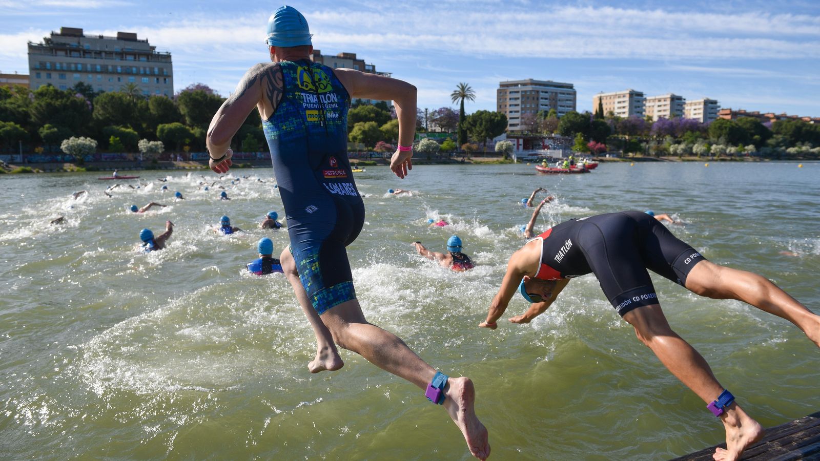 Los participantes se tiran al agua en el segmento de natación.