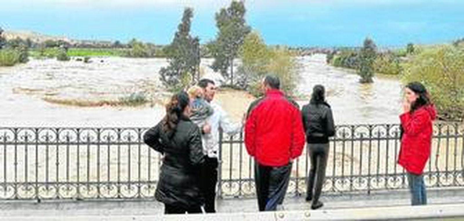 Vecinos de Écija comprueban el desbordamiento del Genil a su paso por la localidad.