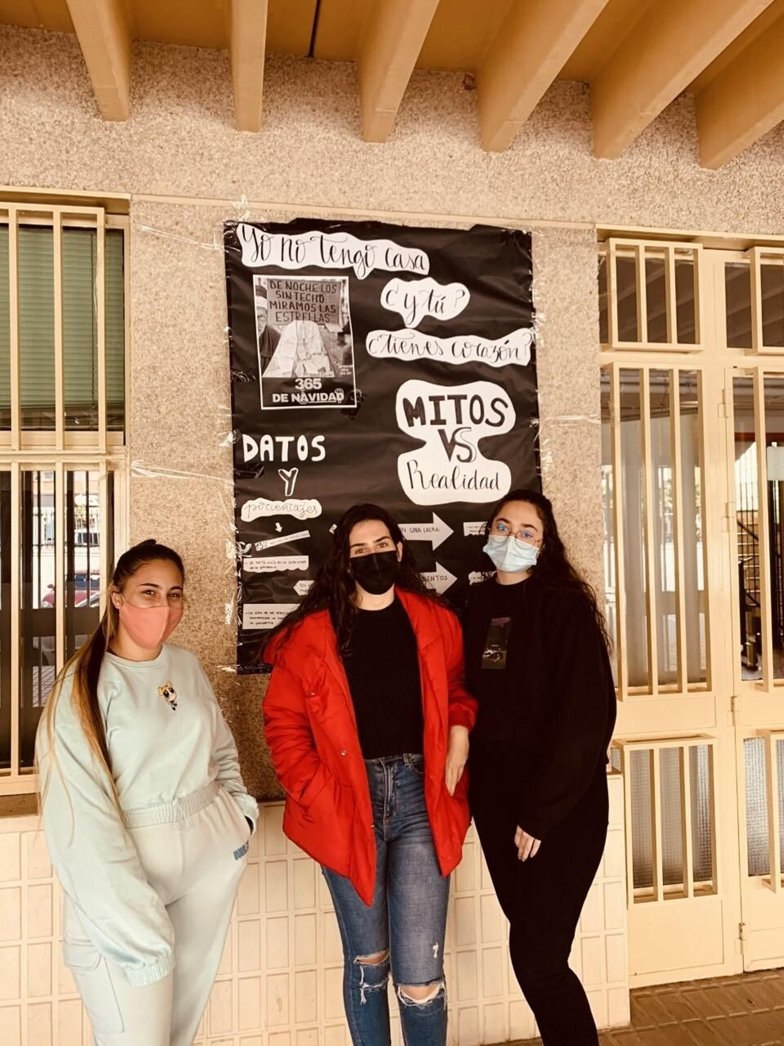 Sara, Elisa y Ángela junto a uno de los carteles.