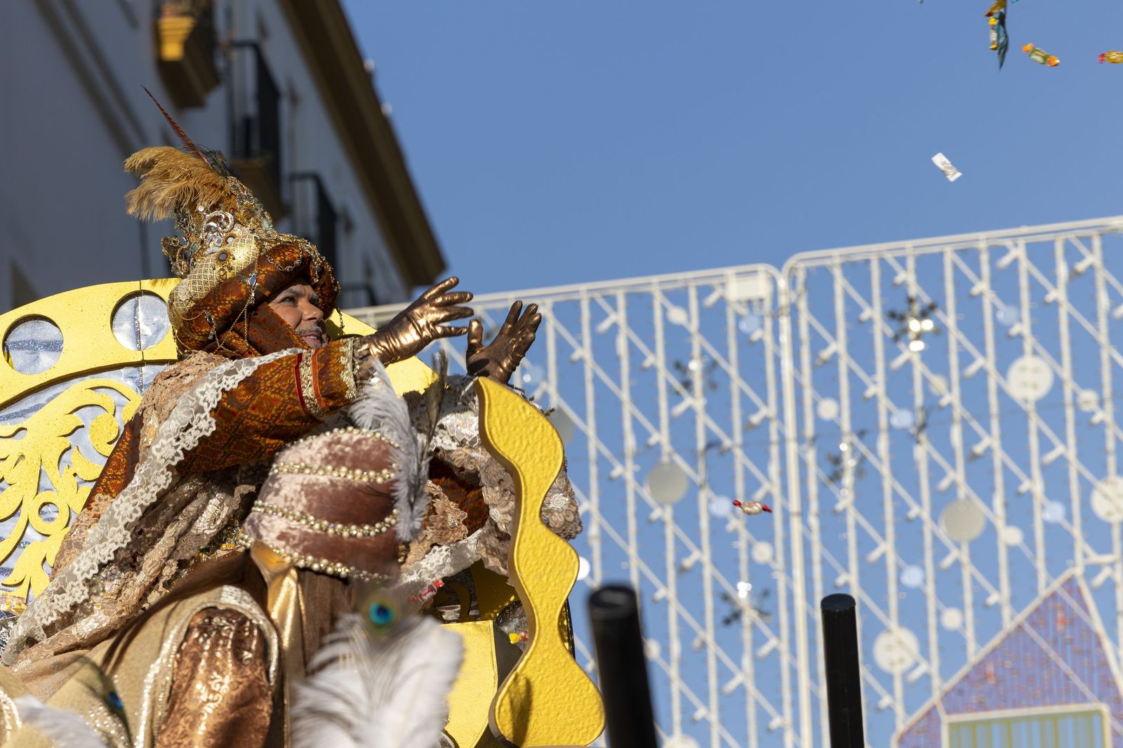El rey Melchor, representado por Juan Magán, repartiendo caramelos a su paso.