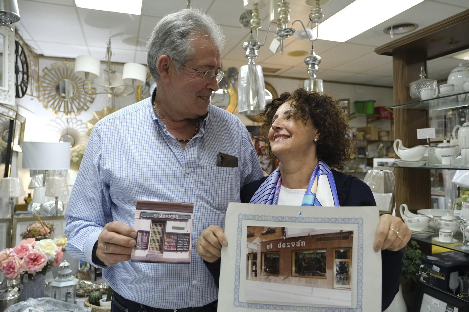Juan y Jaly muestran imágenes históricas de su negocio, que ahora cierra.
