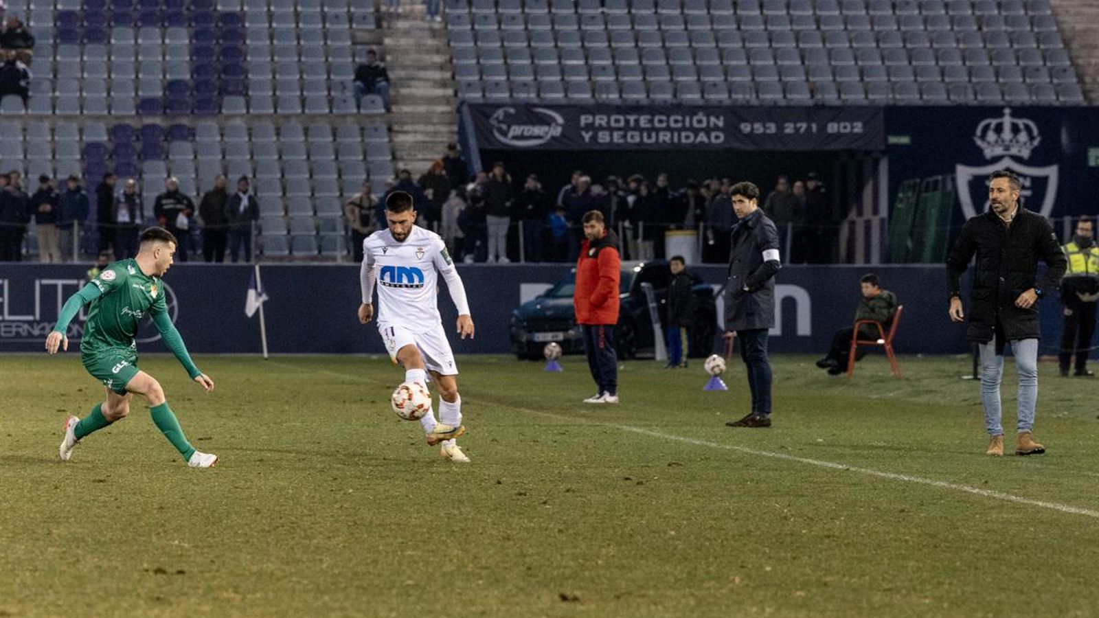 Mario Martos, en el duelo ante el Atlético Mancha Real, ante la mirada de Manolo Herrero.