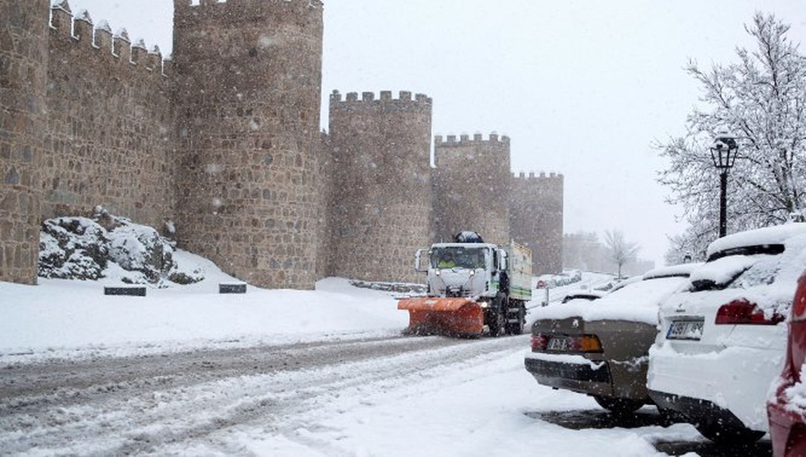 Una maquina quitanieves trabaja para retirar la nieve junto a la muralla de Ávila.
