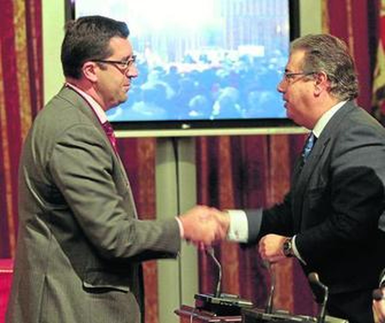 Miguel Bazaga saluda al alcalde tras tomar posesión de su cargo como concejal socialista.