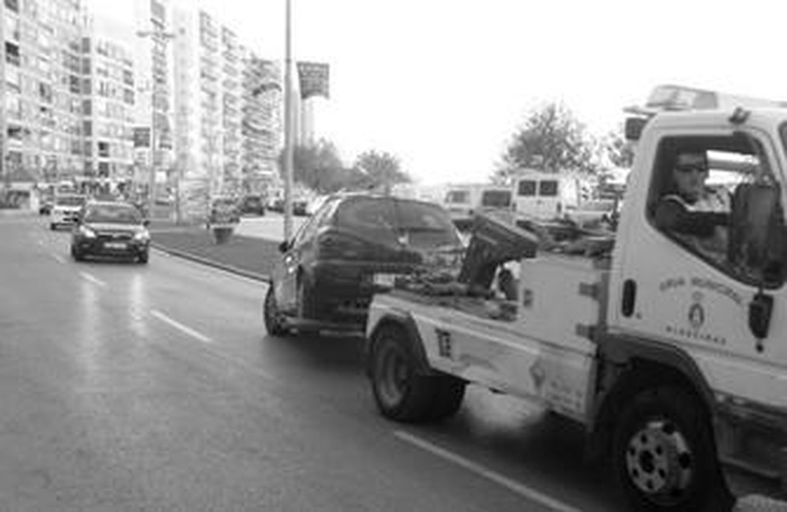 Una grúa traslada por la avenida Virgen del Carmen a un turismo hacia el depósito de vehículos de Algeciras.