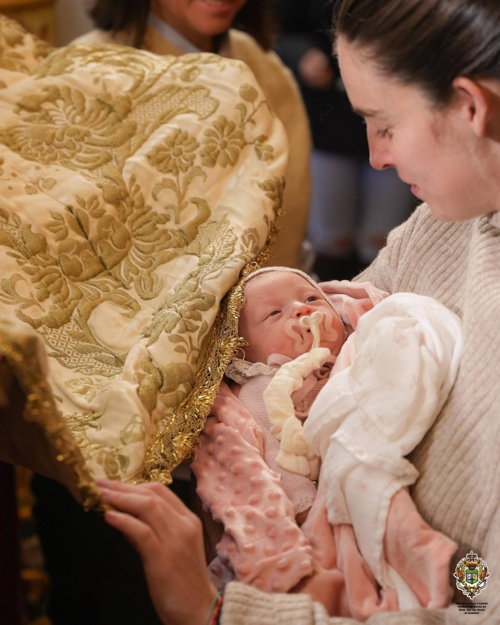 Una madre presenta a su bebé a la Blanca Paloma en La Candelaria este domingo.