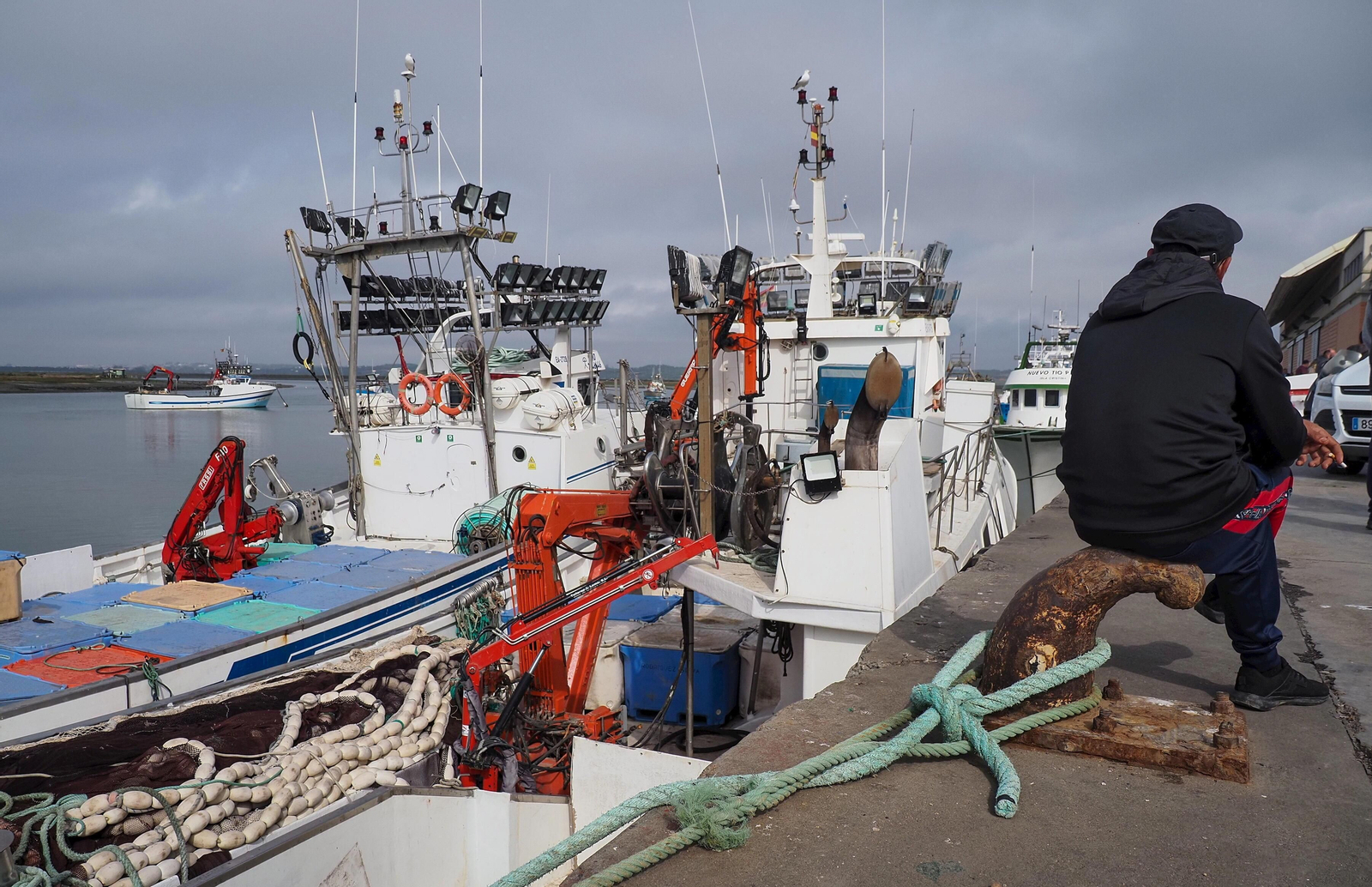 Un marinero observa los barcos durante la parada de la flota en Isla Cristina.
