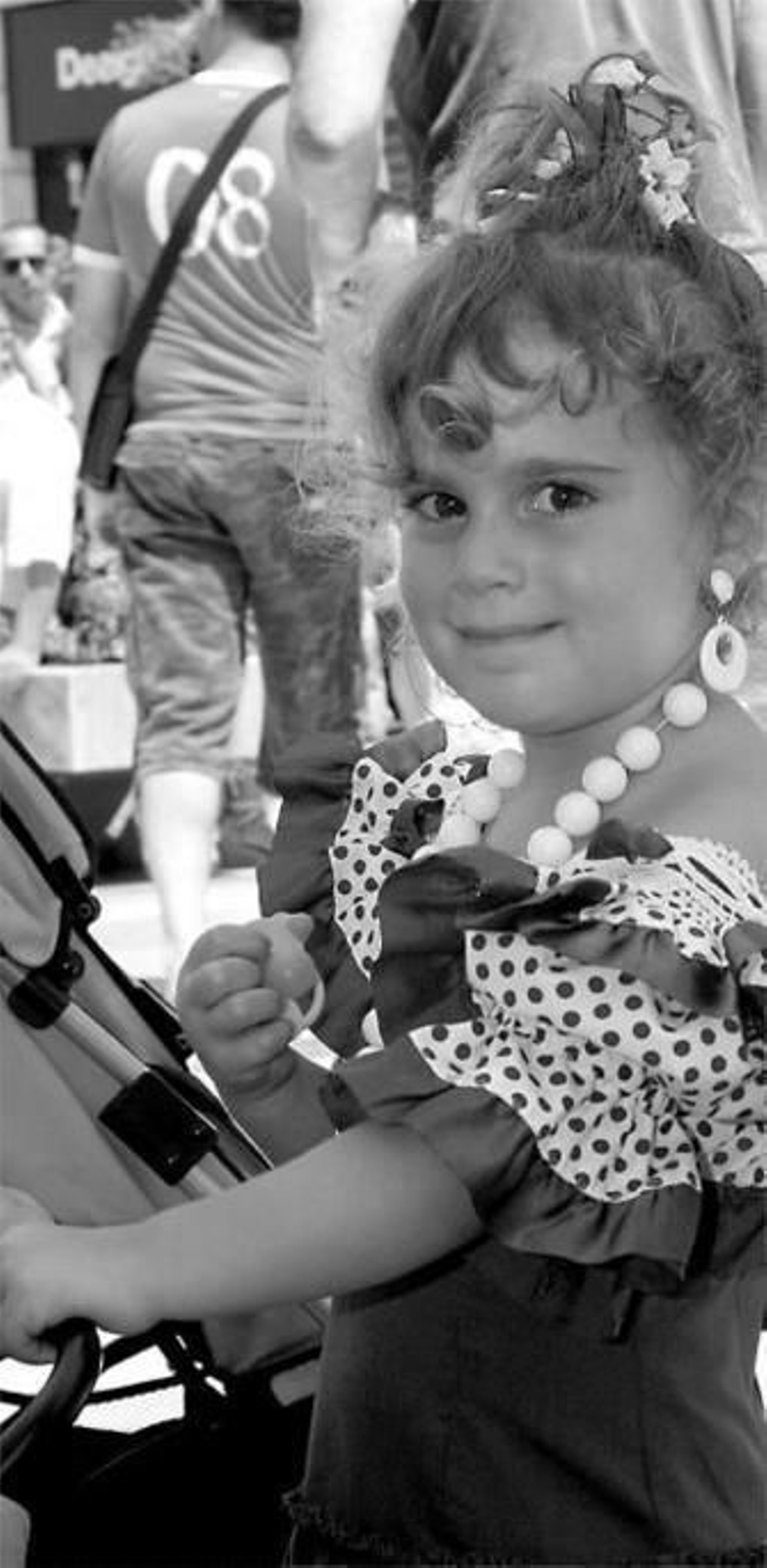 Una chica luce una flor blanca a juego con sus pendientes.