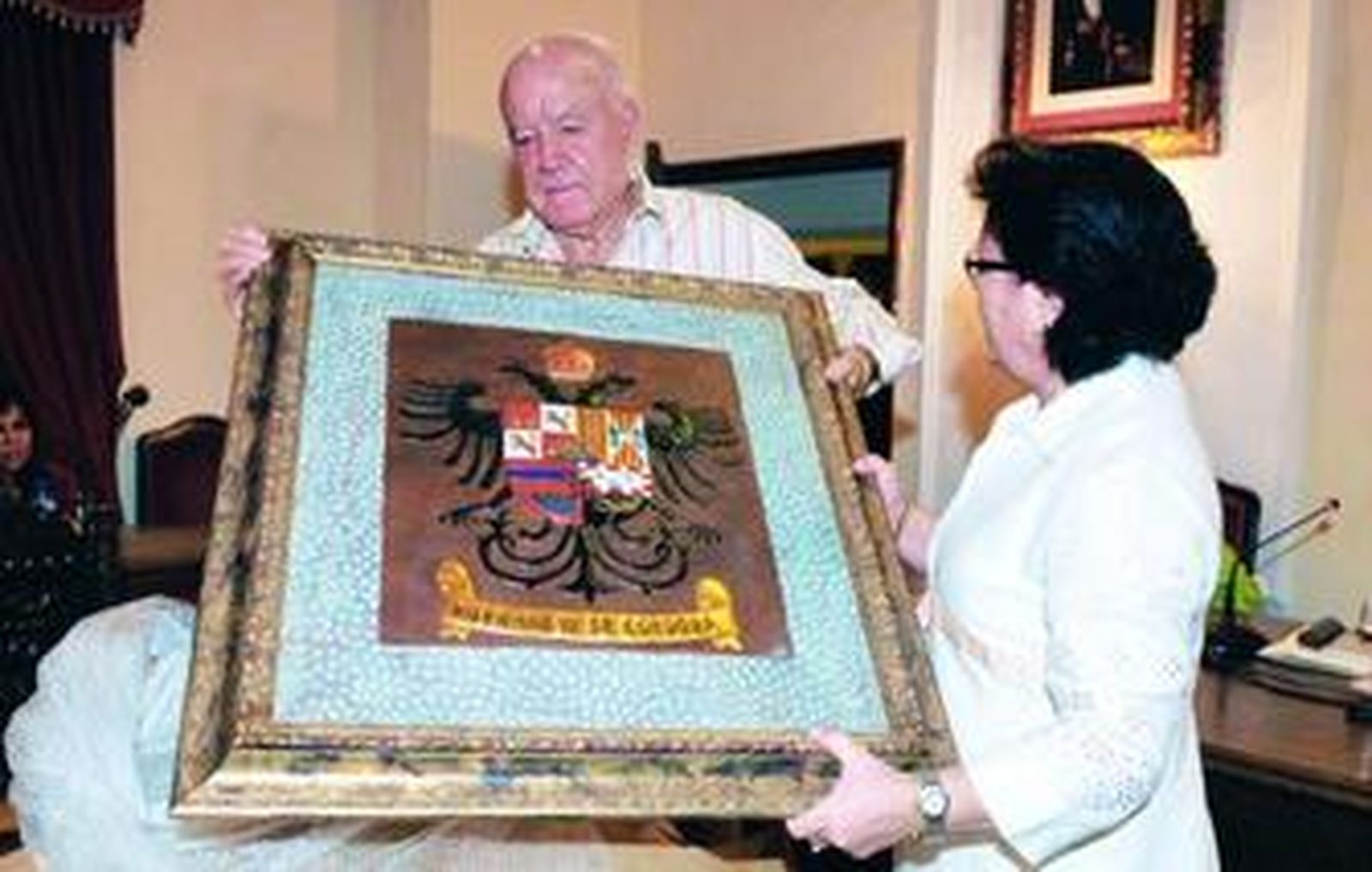 Tomás Muñóz recibe el escudo jarote de manos  de la alcaldesa villanovense, Dolores Sánchez.