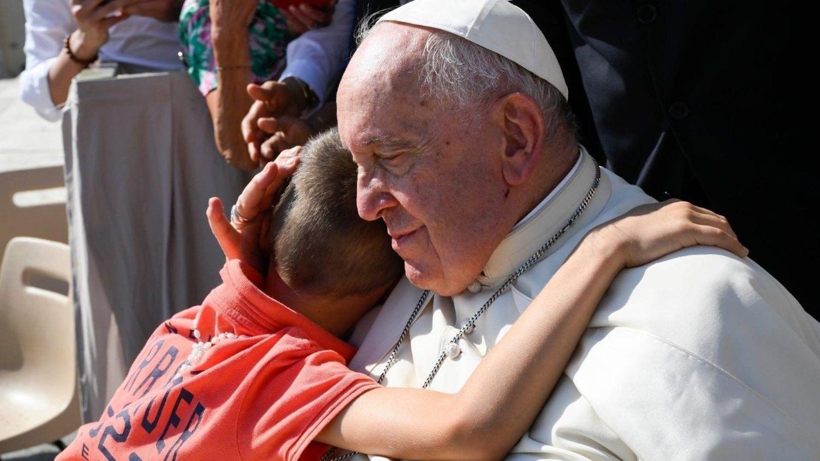 Un niño abraza al Papa Francisco en una audiencia