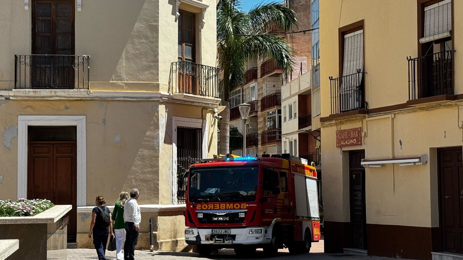 Un coche de bomberos junto al Ayuntamiento de Motril, durante el apagón, ayudando a varios vecinos