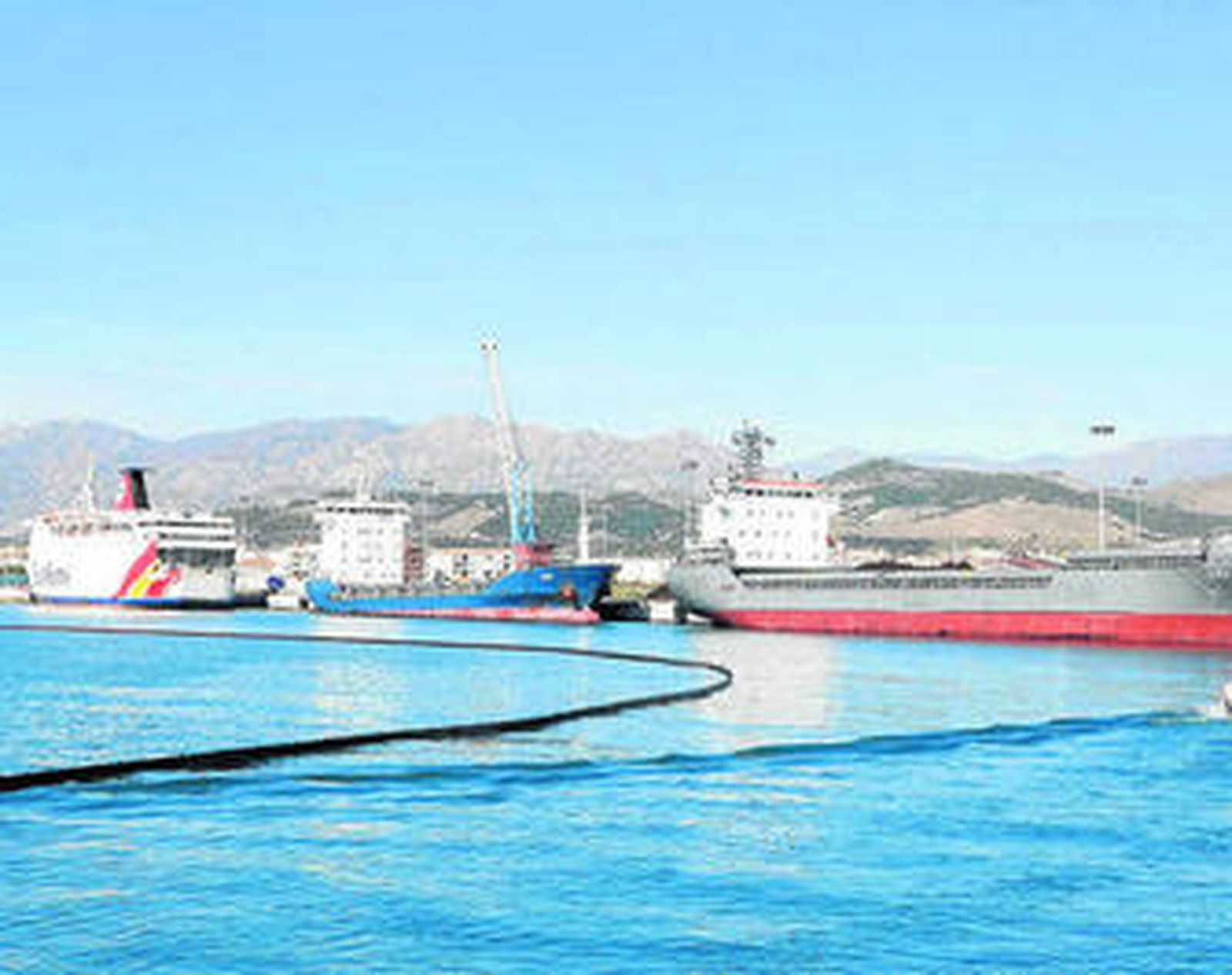 Las barcos implicados y la barrera anticontaminación, ayer, en la dársena motrileña.