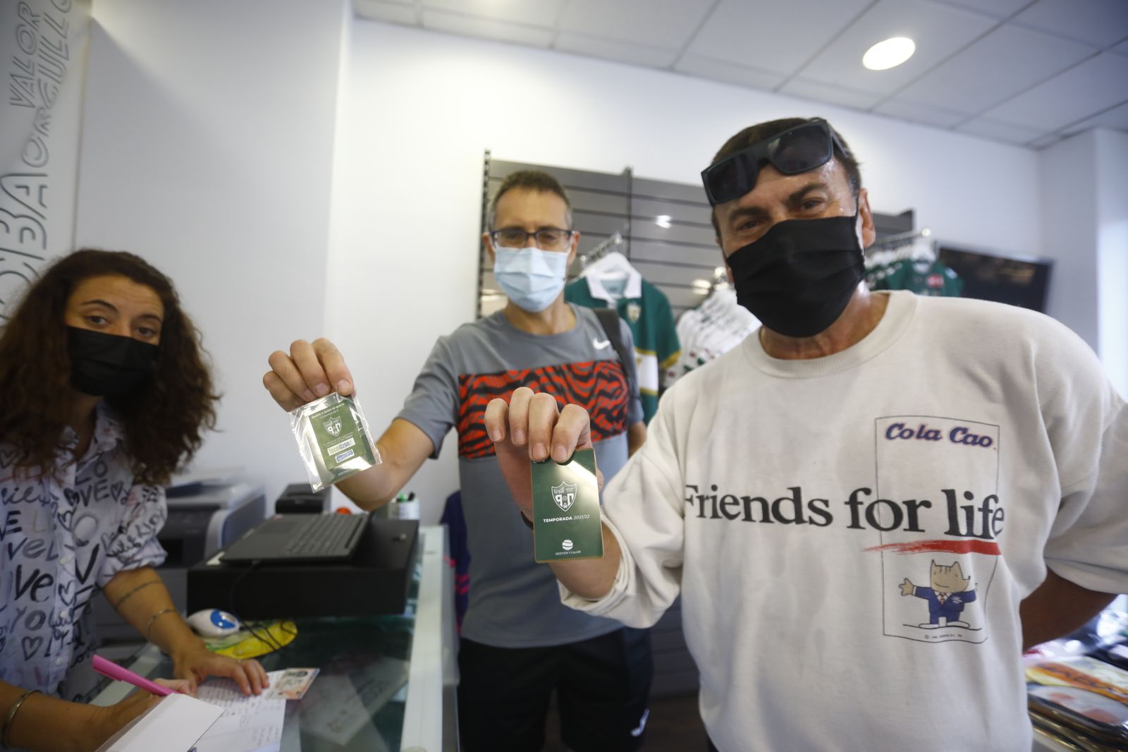 Dos seguidores del Córdoba Futsal recogen los pases anuales de la temporada.