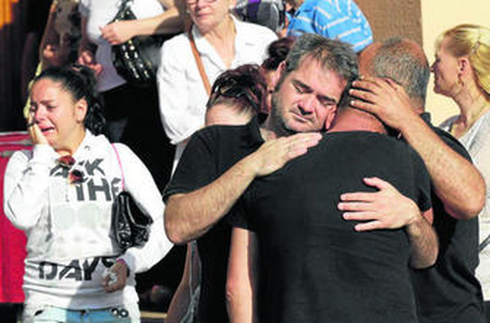 Familiares y amigos de Miriam Tamayo miran su féretro (fuera de imagen) al ser introducido ayer en el coche fúnebre.