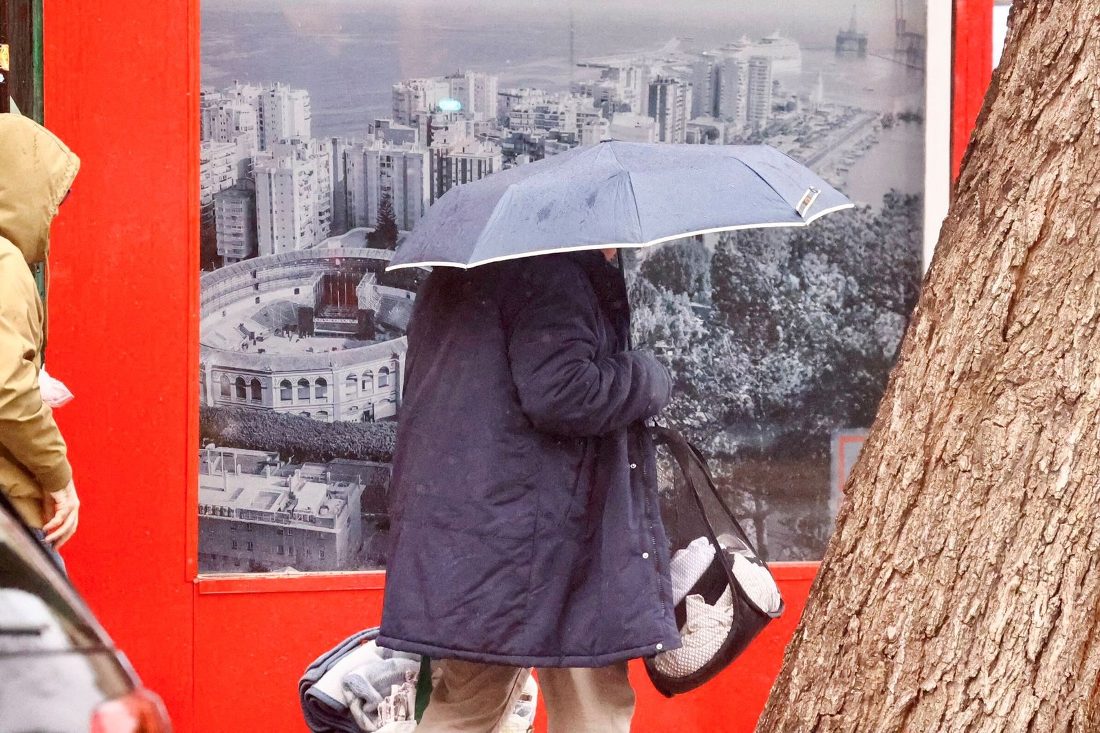 Una persona se protege de la lluvia en Málaga con un paraguas.