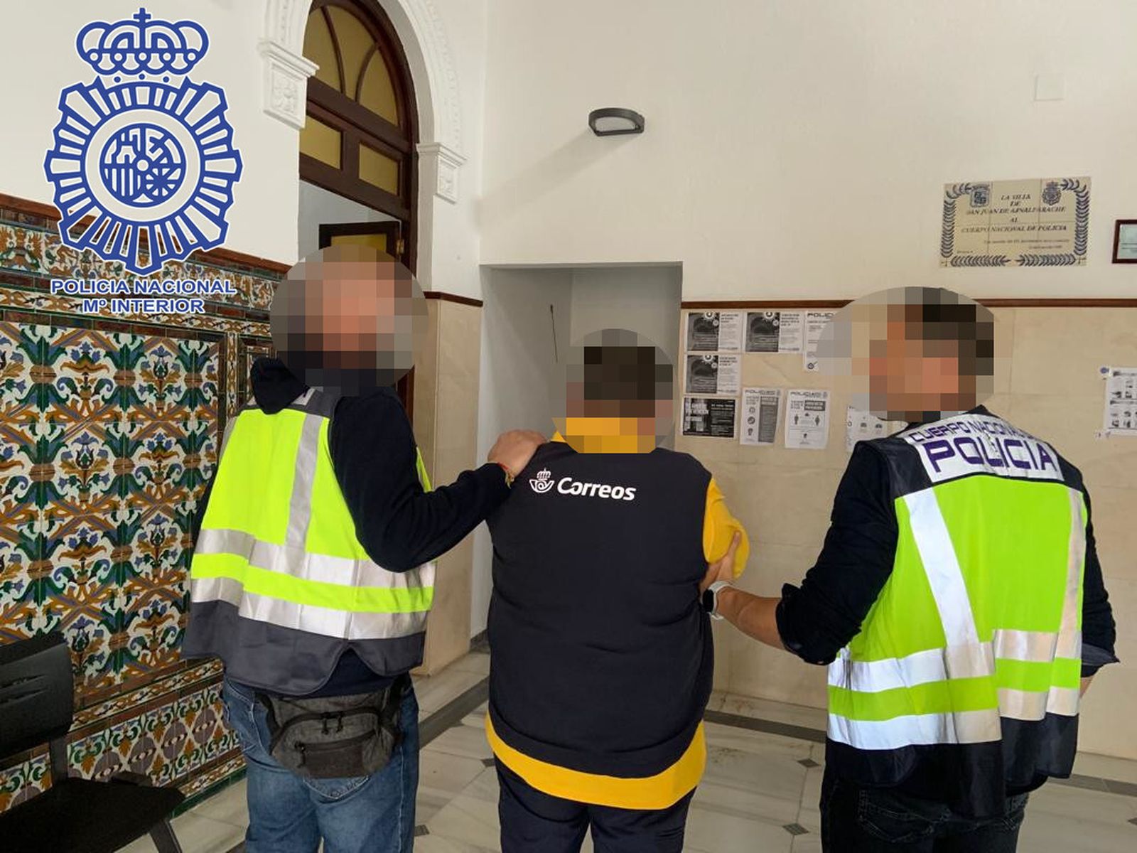 Dos policías trasladan al empleado de Correos detenido.