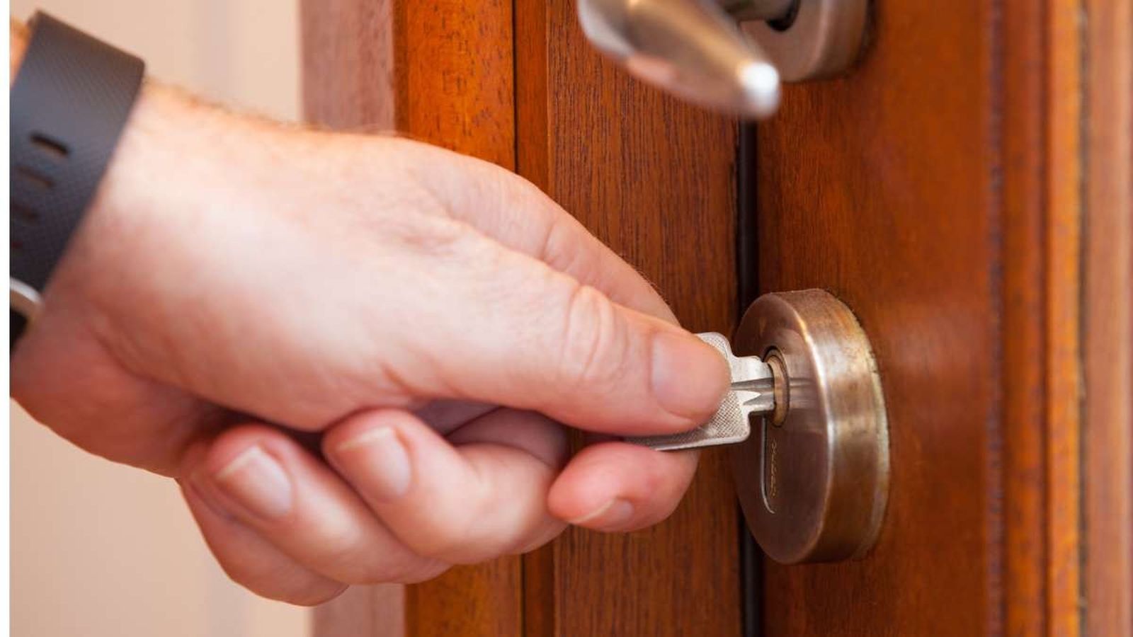 Una persona dejando la llave de casa en la puerta