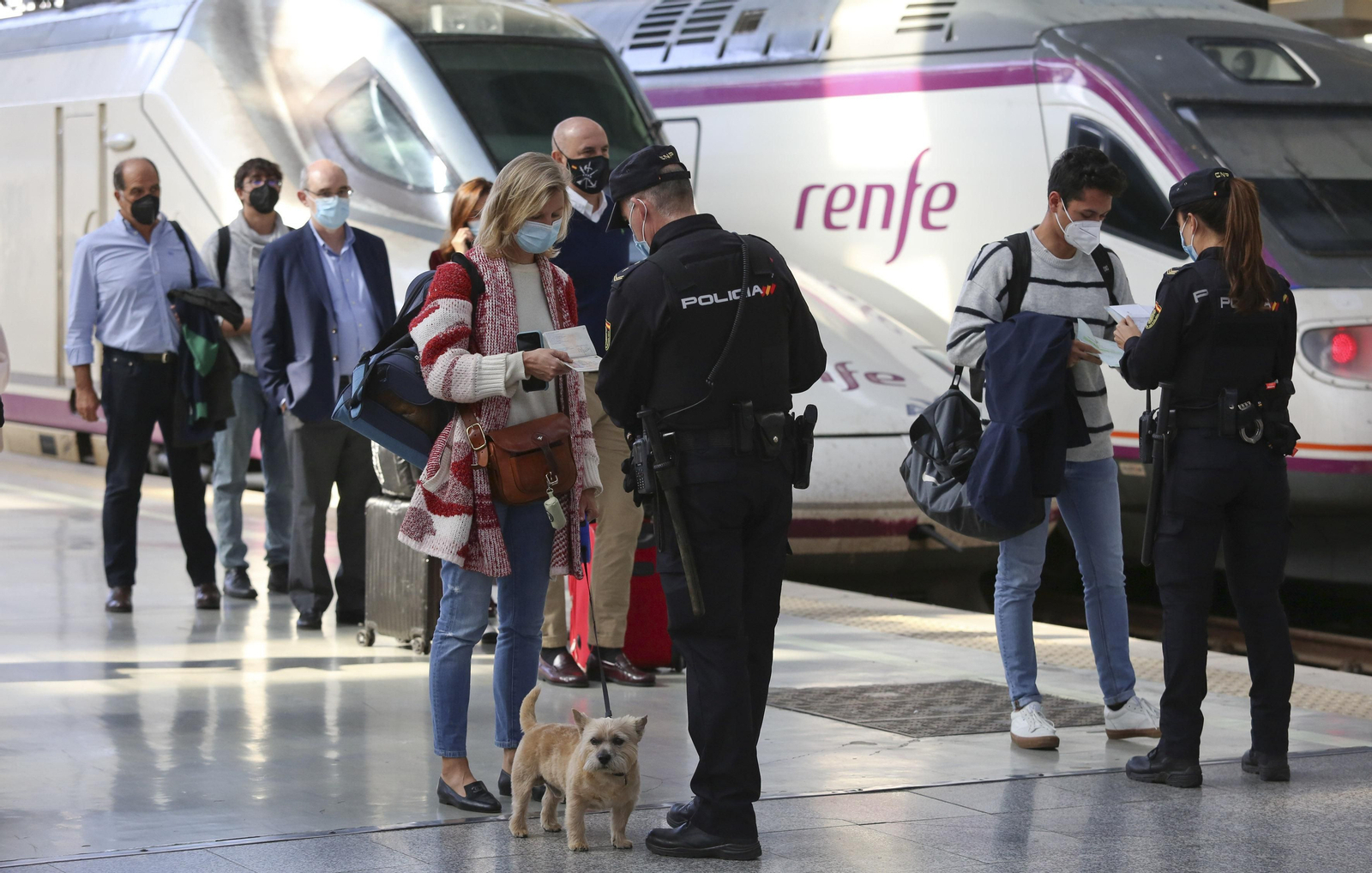 Una mujer con su mascota le enseña el billete a un policía.