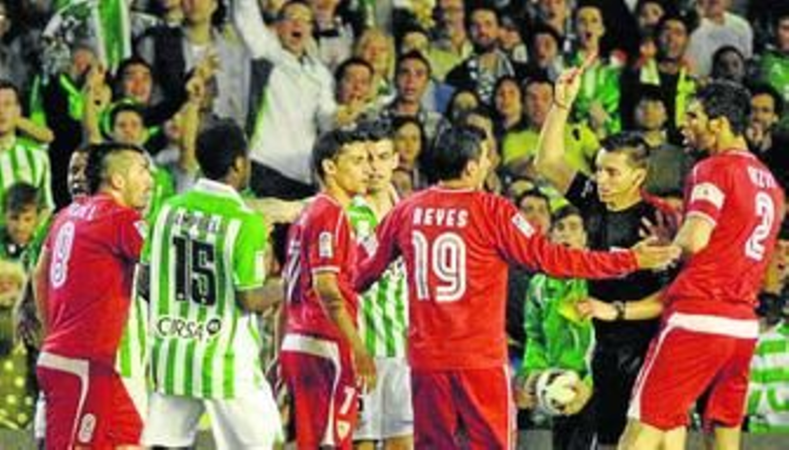 Del Cerro Grande, rodeado de jugadores del Sevilla y del Betis, muestra la roja a Medel en la polémica acción con Cañas.