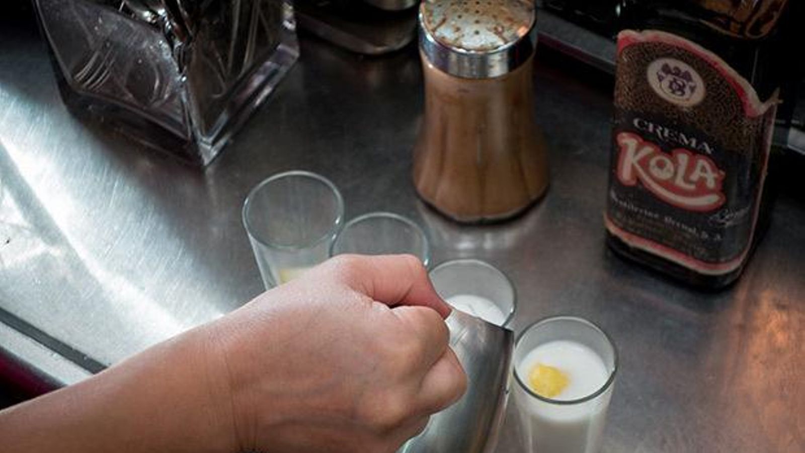 Una curiosa bebida caliente de color rosa coronada con una piel de limón y canela