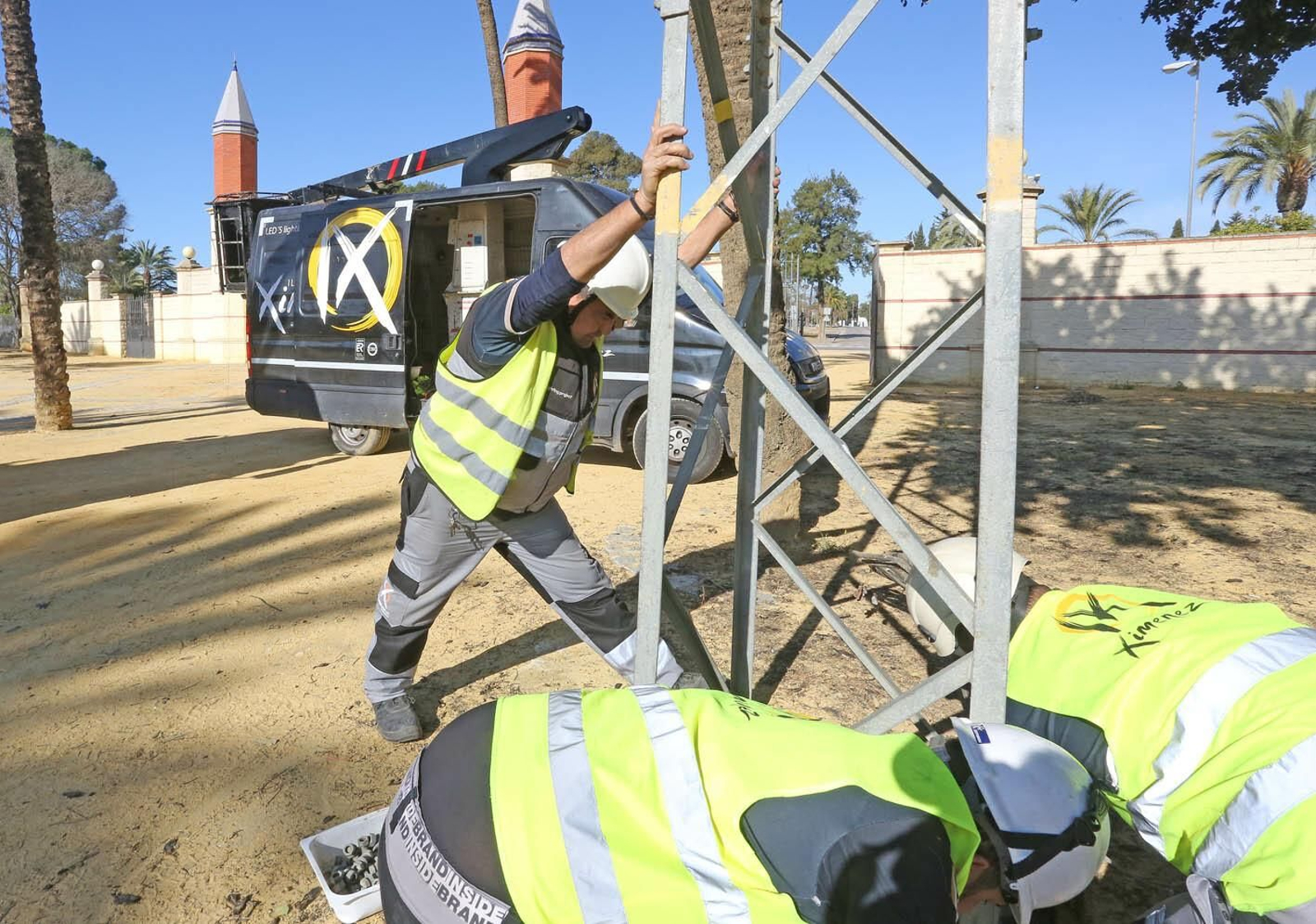Varios operarios colocan una torreta de luz.