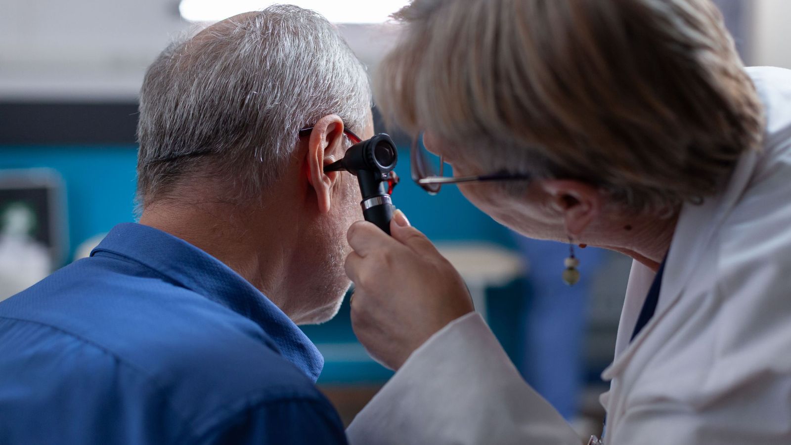 Doctora sostiene un otoscopio para hacer una consulta de oído.