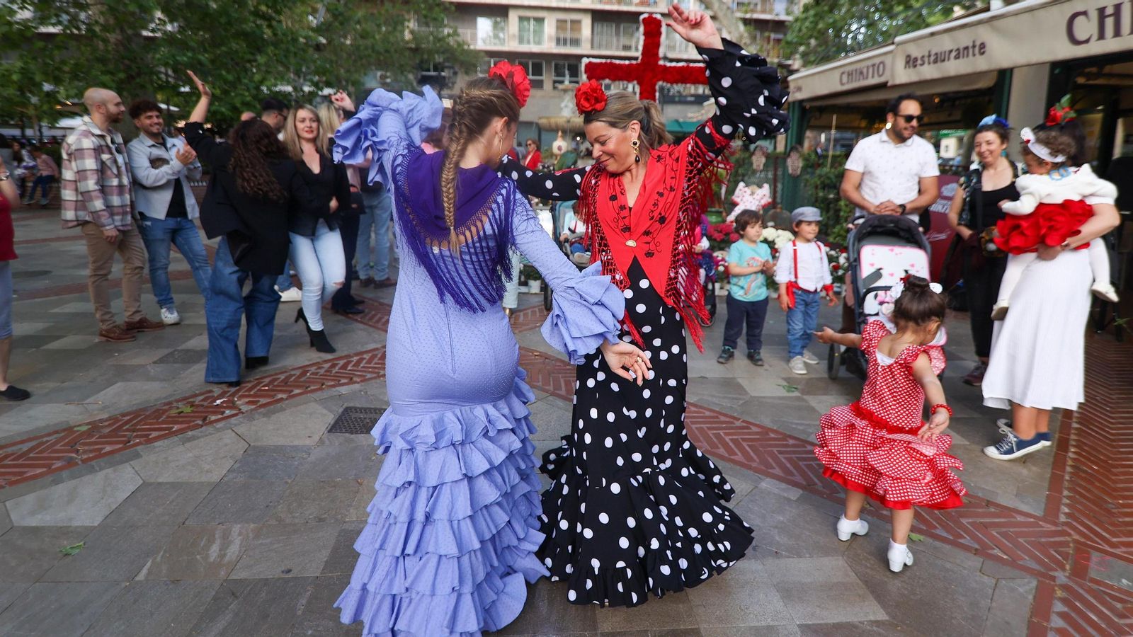 Dos mujeres bailan en la Cruz de la calle Matilde Cantos